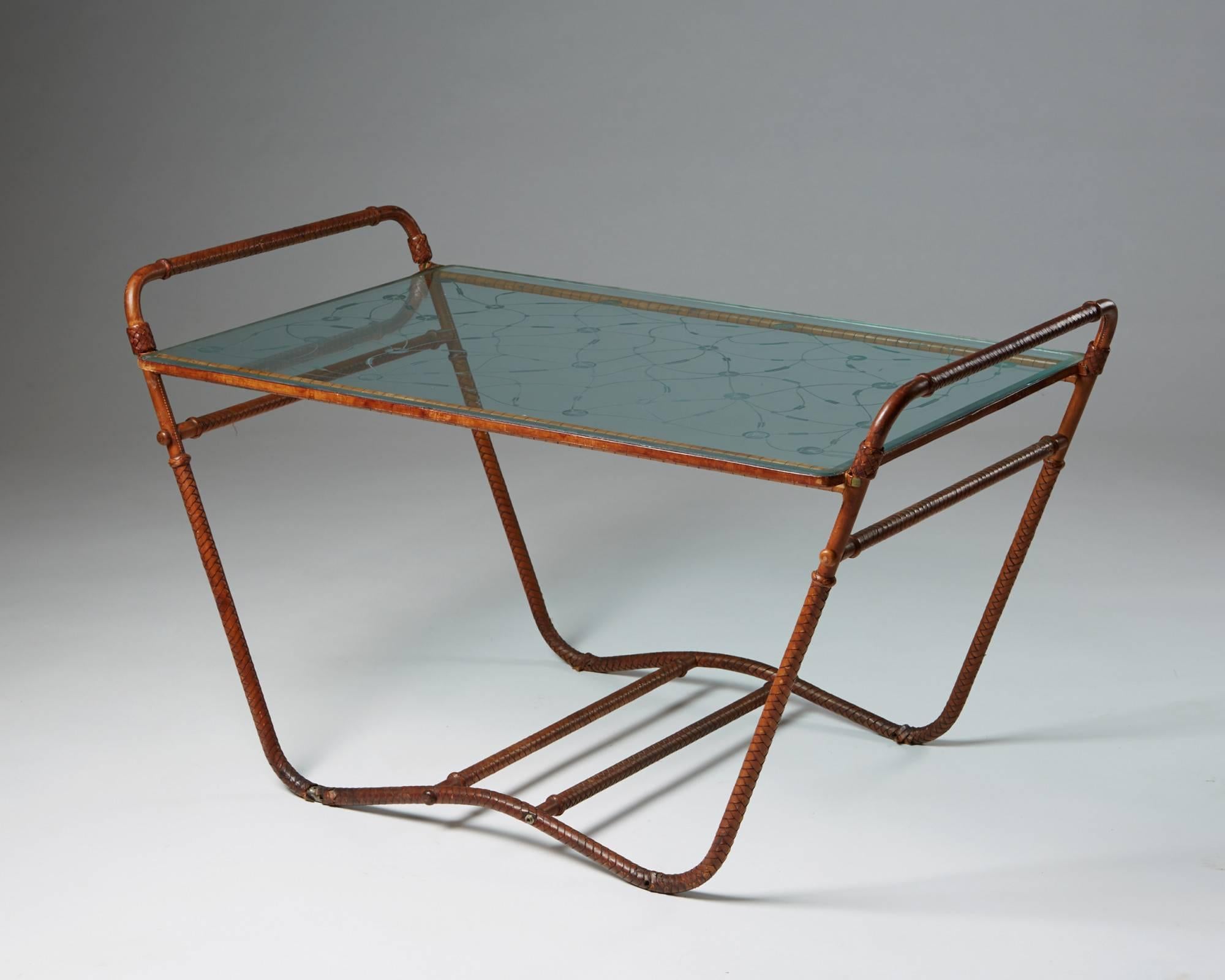 Occasional table, anonymous, Sweden, 1940s. Steel, leather and glass.

Measures: H: 58 cm/ 22 1/2''
L: 101 cm/ 39 1/2''
D: 60 cm/ 23 3/4''.
 