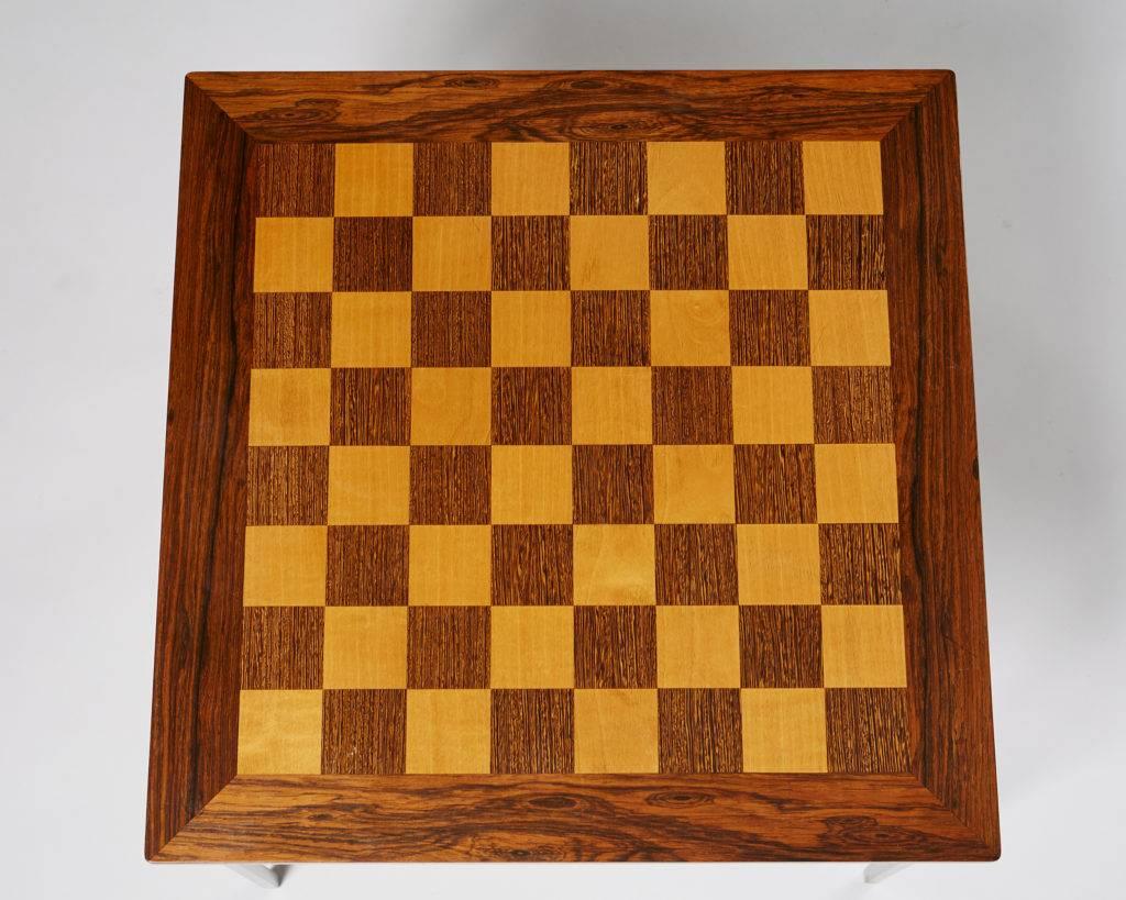 Chess table designed by Knud Joos,
Denmark, 1960s.

Rosewood, with light wood and wengé squares, steel legs.

Measures: H 41 cm/ 16 1/8