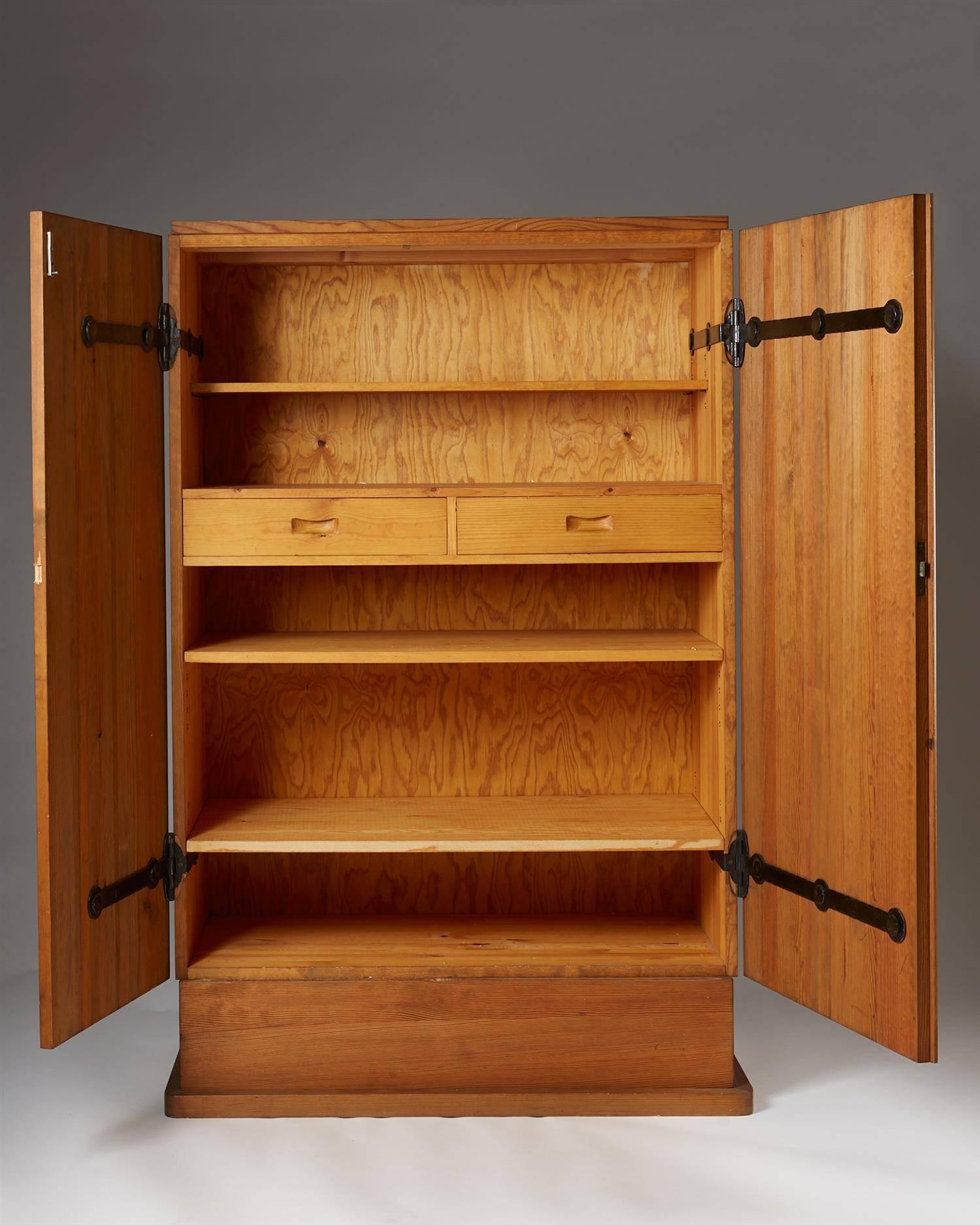 Cabinet Lovö, designed by Axel-Einar Hjorth for NK, Sweden. 1932.
Pine and forged iron.

H: 156 cm/ 5' 1 1/2''
W: 100 cm/ 39 1/2''
D: 45 cm/ 17 3/4''