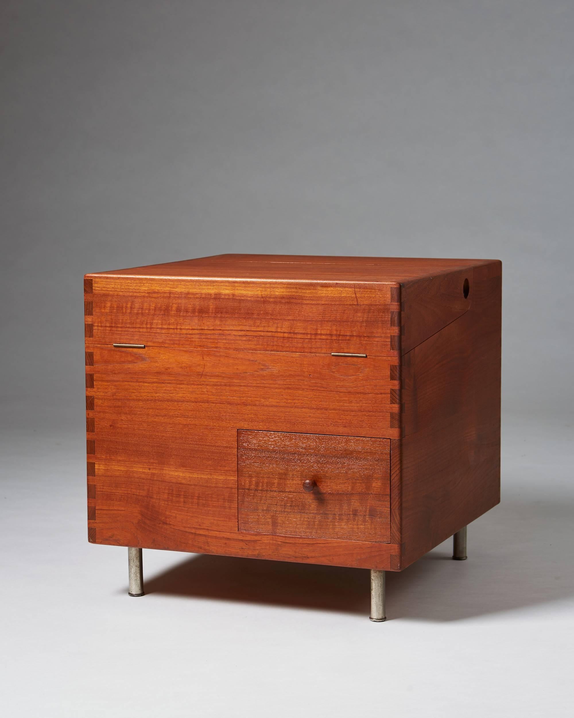 Bar cabinet model 8034, designed by Hans Wegner for Andreas Tuck,	
Denmark. 1956.

Teak.

H: 50 cm/ 19 3/4''
W: 50 cm/ 19 3/4''
D: 52 cm/ 20 1/2''