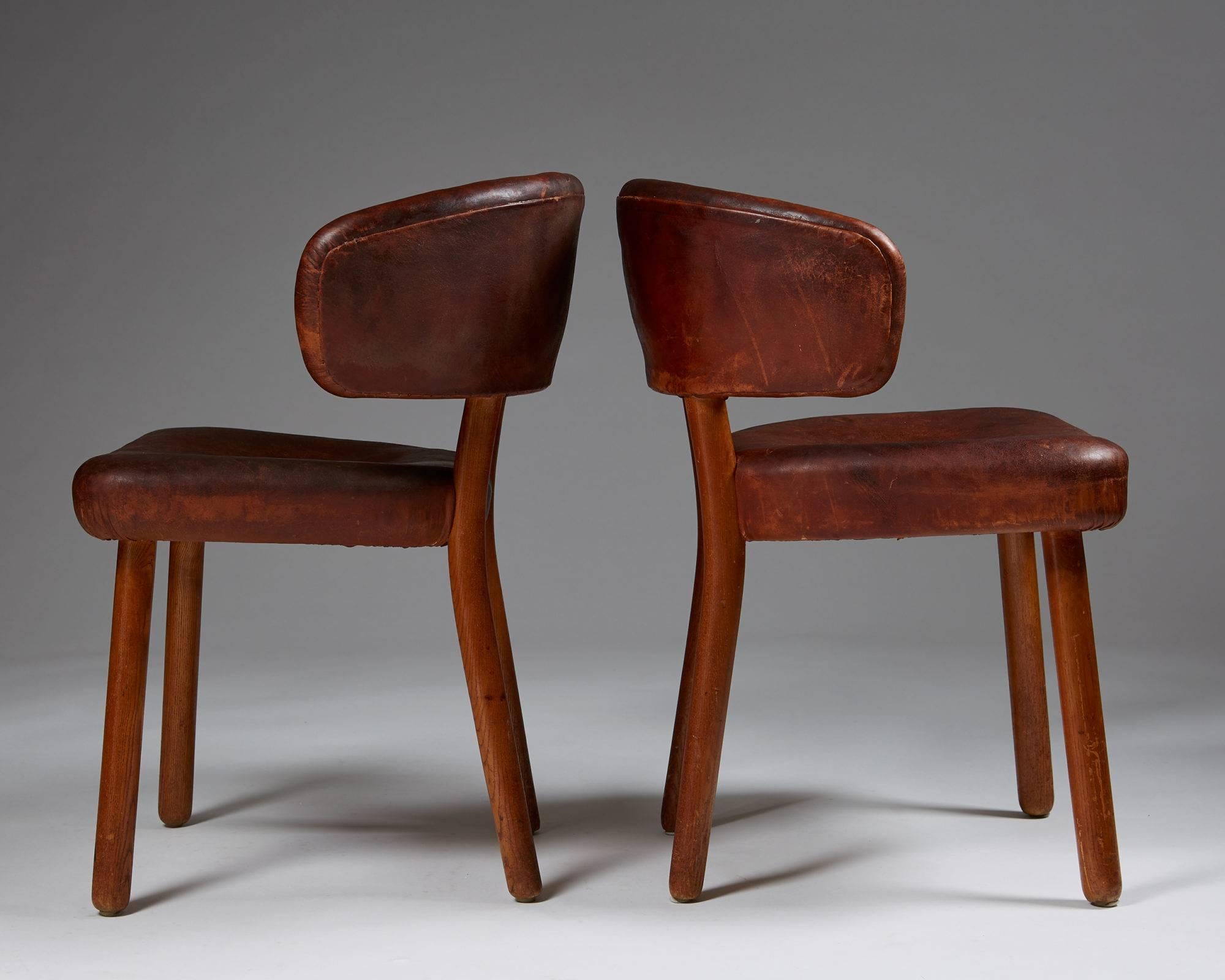 Pair of chairs designed by Hans-Christian Hansen and Viggo Jörgensen for Johannes Hansen, Denmark. 1936.
Ash legs with original cognac leather.

This model presented at the Danish Carpenter's Guild Exhibition, Copenhagen, 1936.
The model was