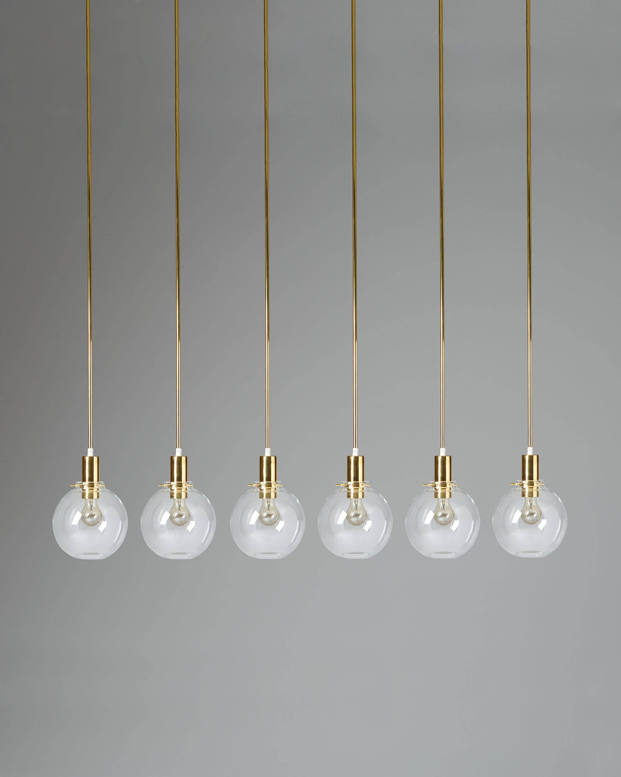 Long ceiling lamps designed by Hans-Agne Jakobsson, Sweden, 1960s.
Brass and glass.
Six available.