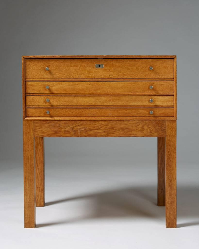 Cutlery chest of drawers, anonymous, 
Denmark. 1950s.

Solid oak and nickel-plated brass.
Measures:
H: 76 cm/ 2' 6 7/8''
W: 68 cm/ 2' 3 1/4''
D: 46 cm/ 18 1/8''.