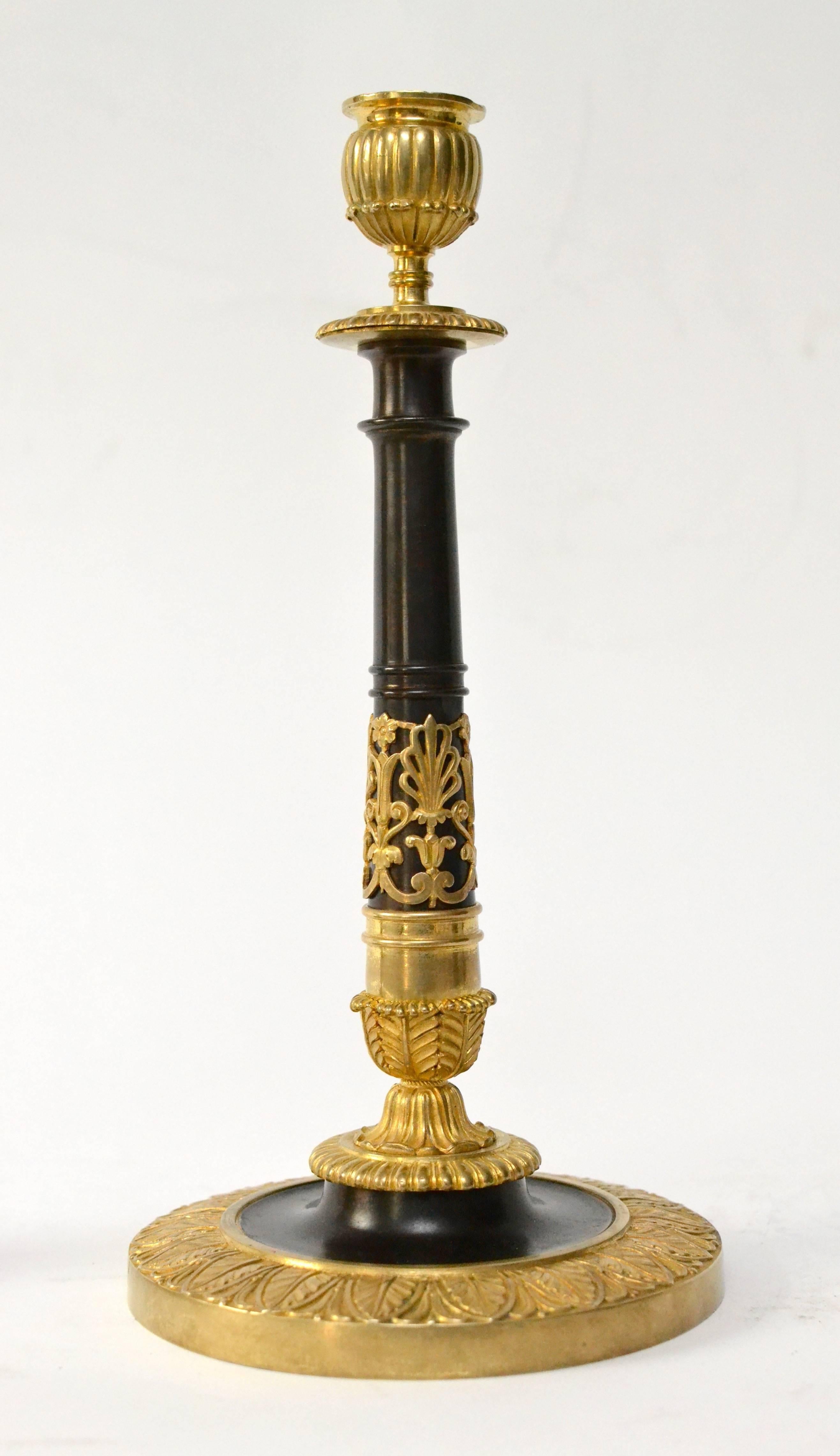 A pair of gilt and patinated bronze candlesticks, early 19th century.