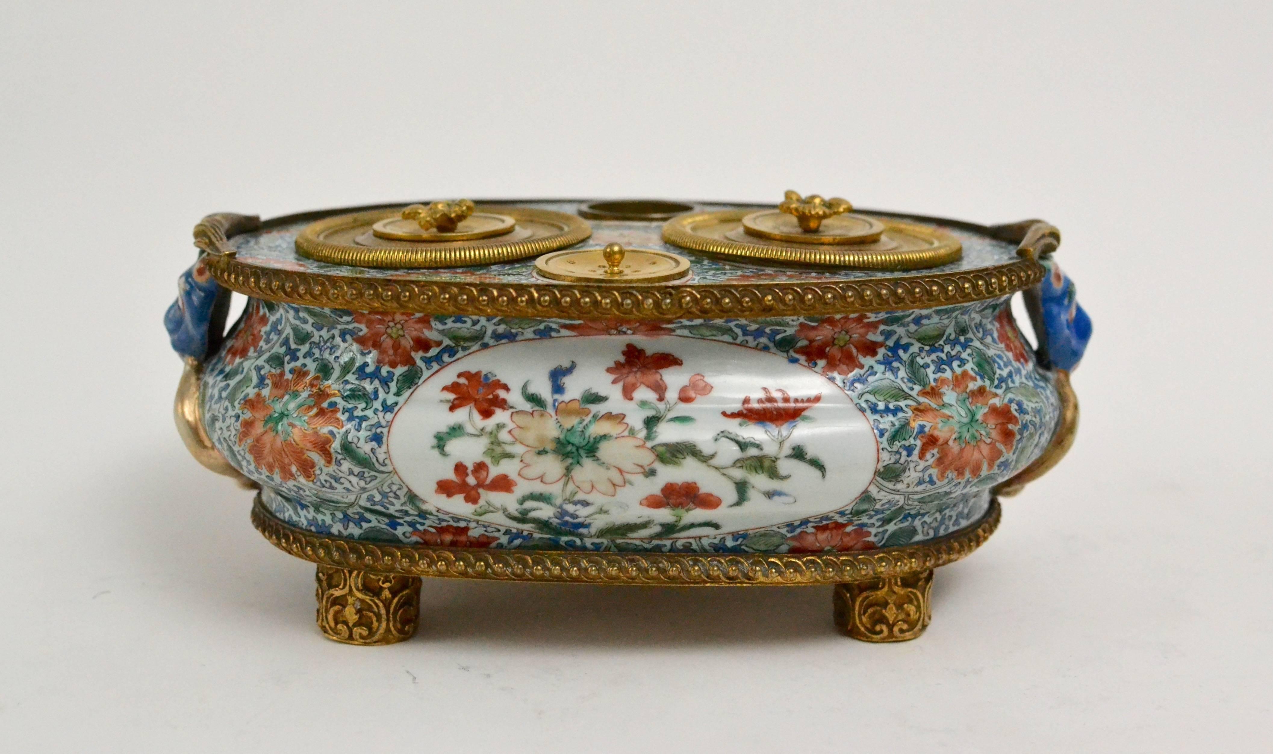 A Chinese 18th century ormolu-mounted famille verte inkstand.

A stand of this form with Spanish arms that can be dated precisely to 1742 is illustrated by A. Diez de Rivera, The Spanish Market, Oriental Art, vol. XLV, no 1, p 41.