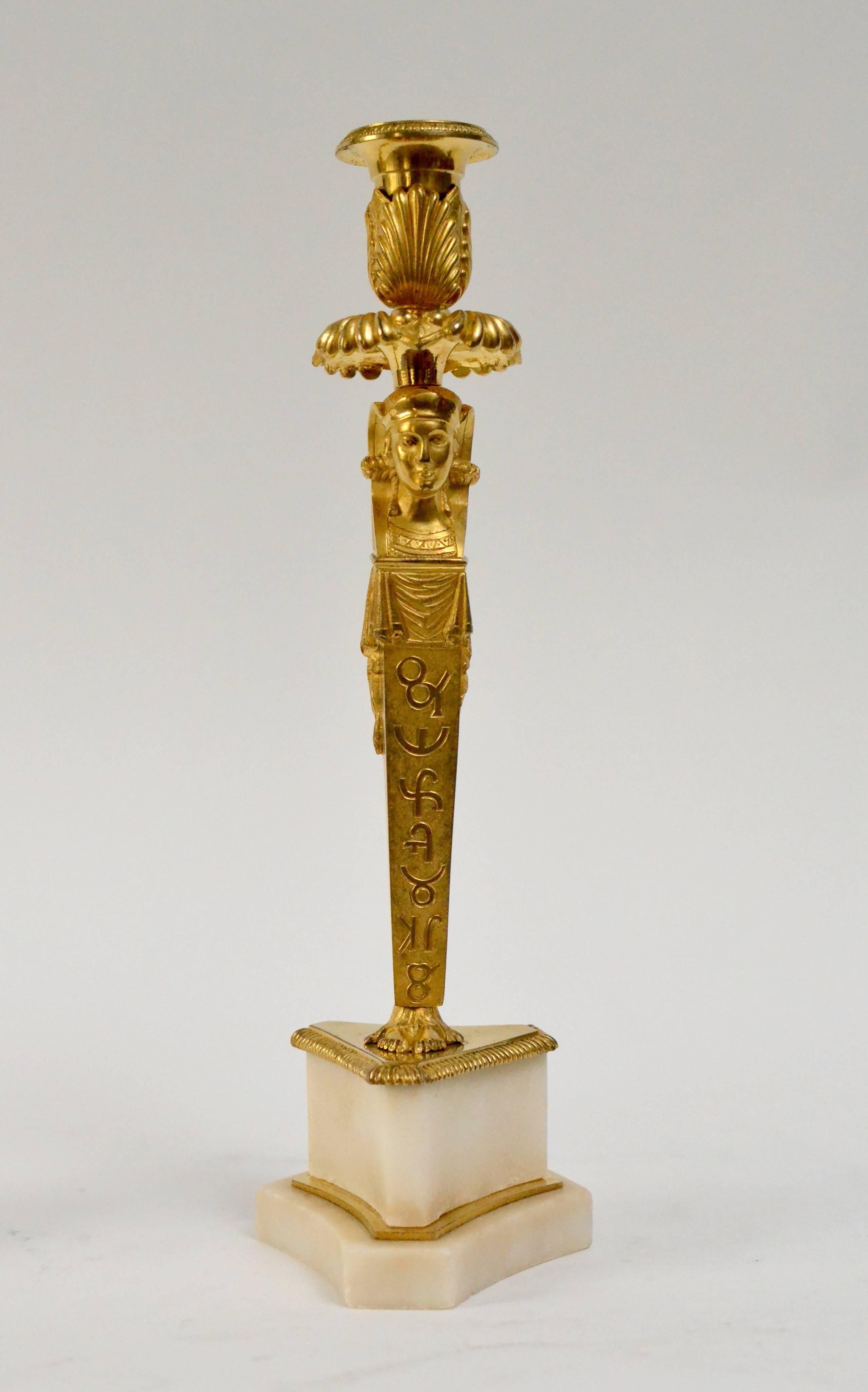 A rare pair of Egyptian style empire gilt bronze and marble candlesticks, circa 1800-1810.