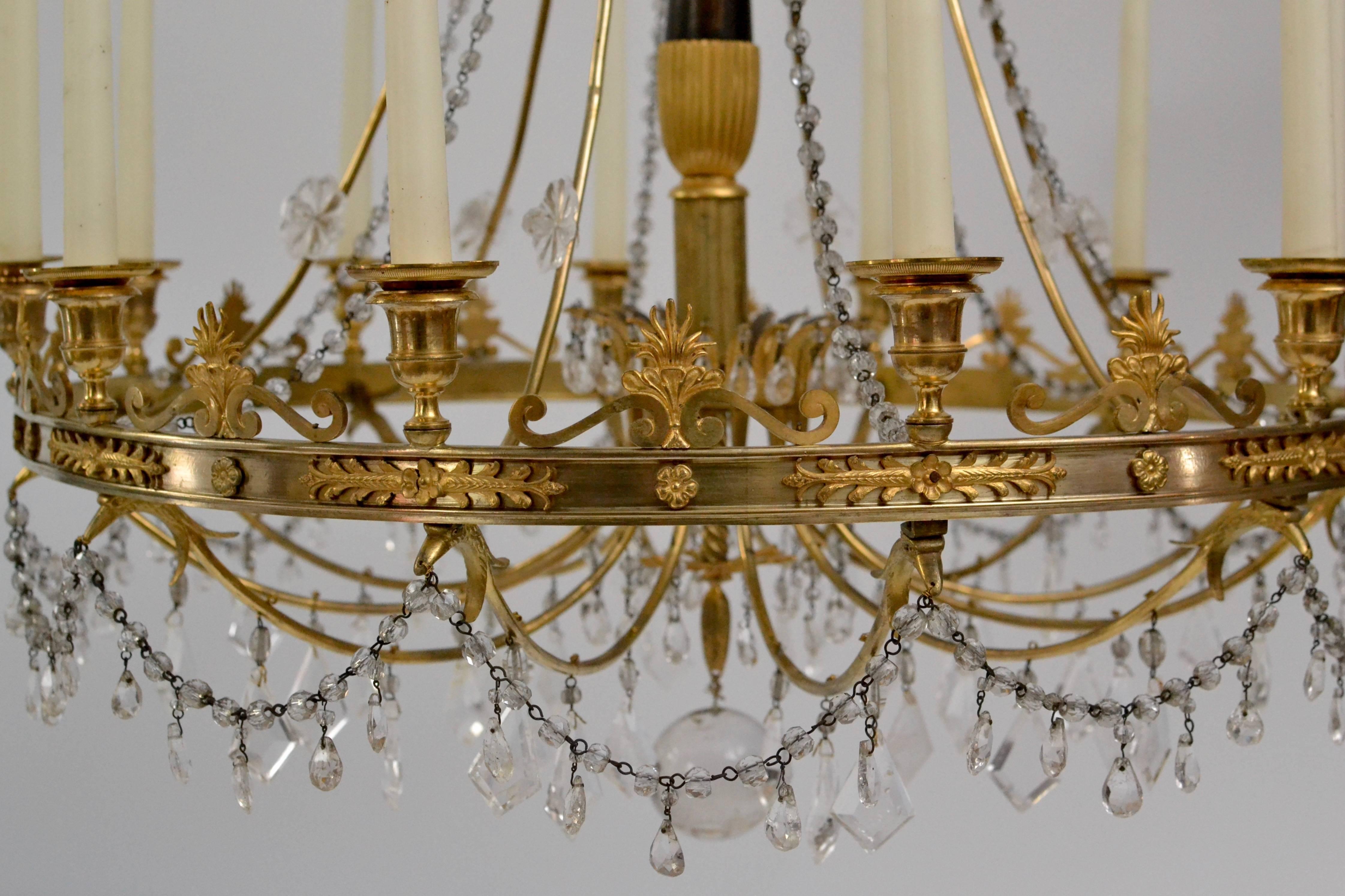 A French early 19th century gilt and patinated bronze chandelier with crystals.
