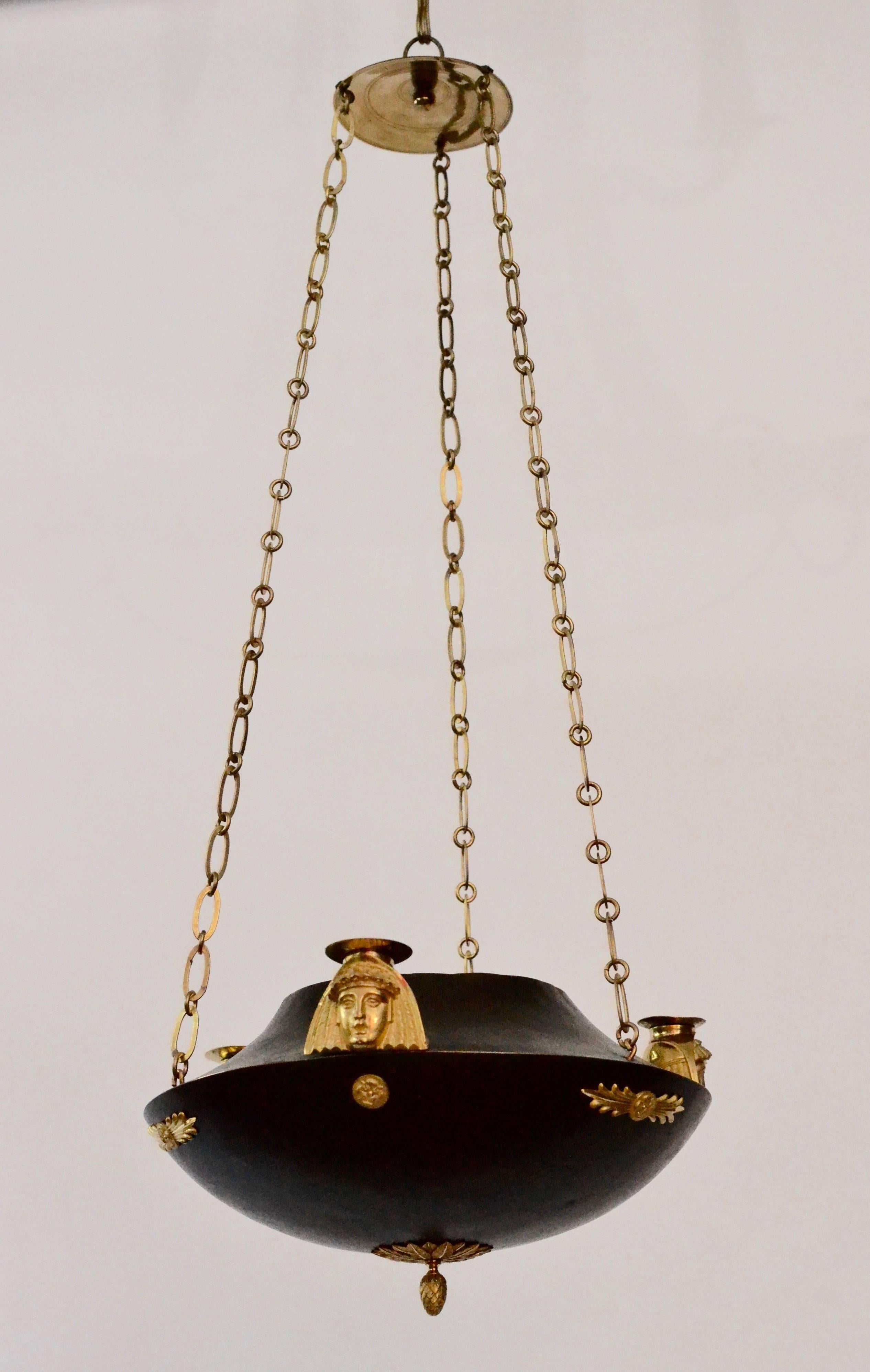An unusual patinated and gilt bronze Swedish chandelier in the Egyptian style, circa 1810.