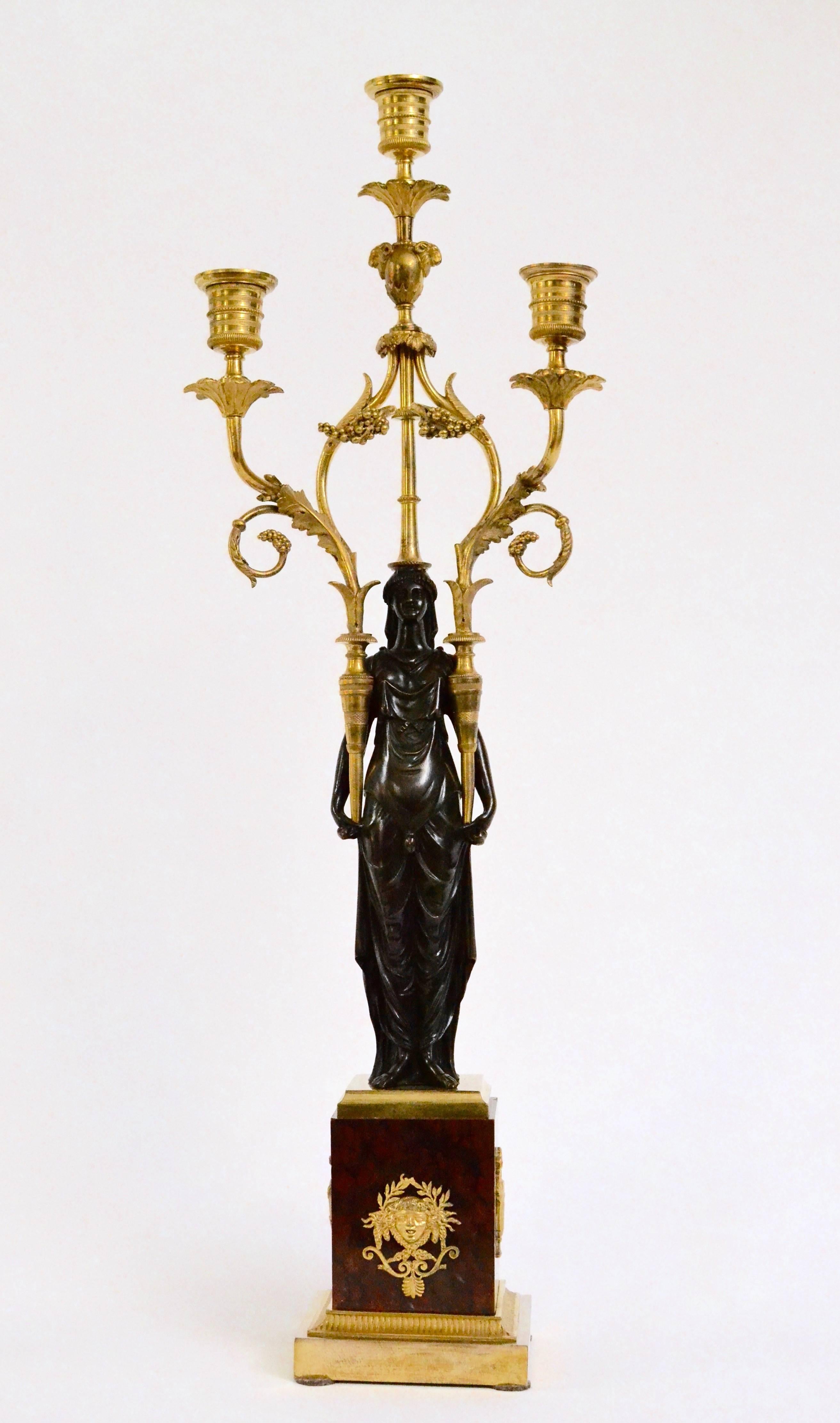 A pair of Louis XVI gilt and patinated candelabra on red Griotte marble bases, circa 1790.