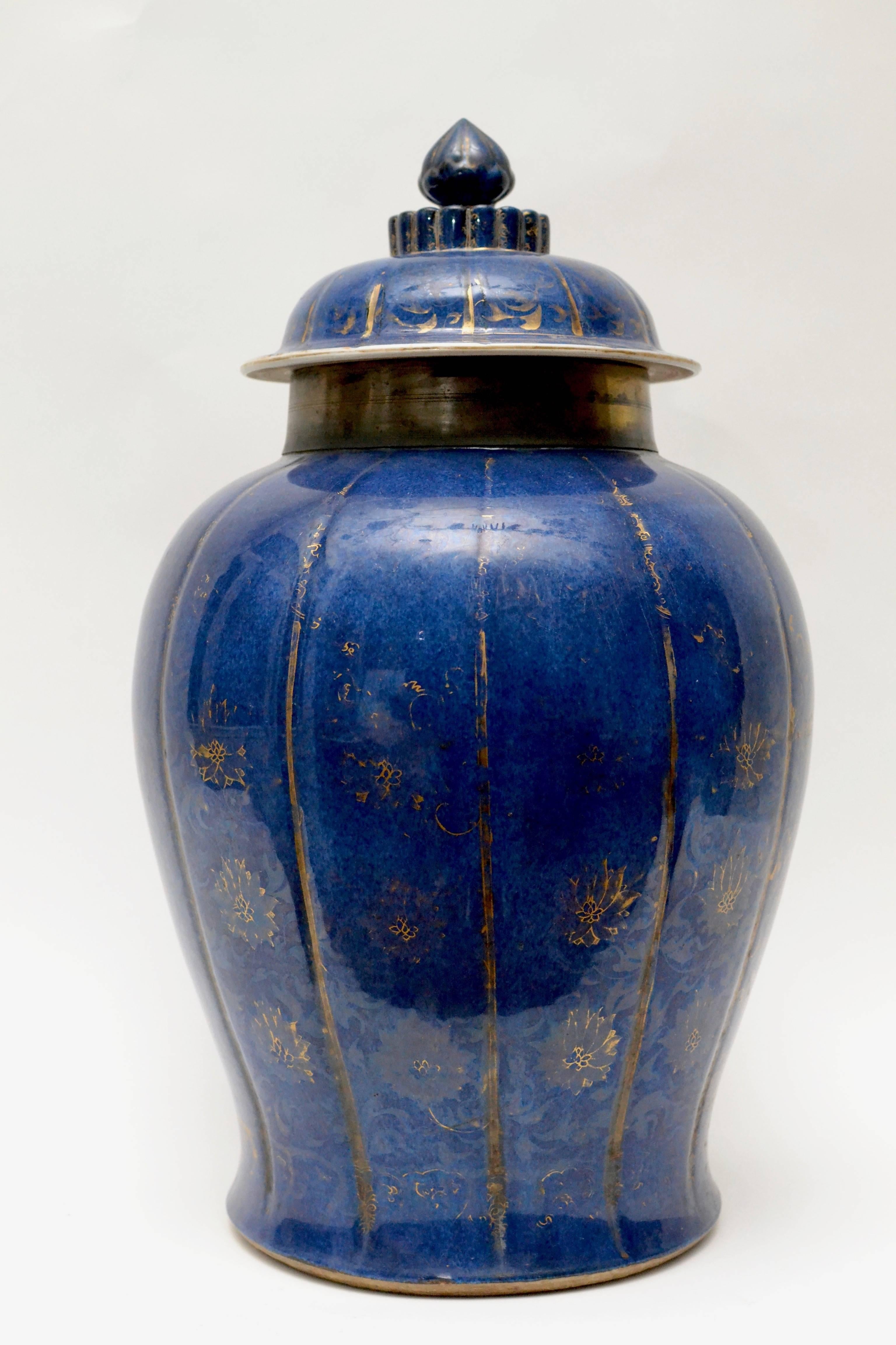 A Chinese powder blue and gilt urn with a lid from the Kangxi period (1661-1722). The neck of the urn mounted in brass.