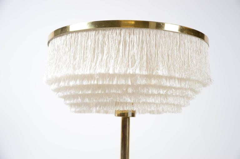 Brass table lamp with silk fringe. Designed by Hans-Agne Jakobsson for Markaryd, Sweden, 1960s. With original label. 

Measures: Height circa 62 cm. 

