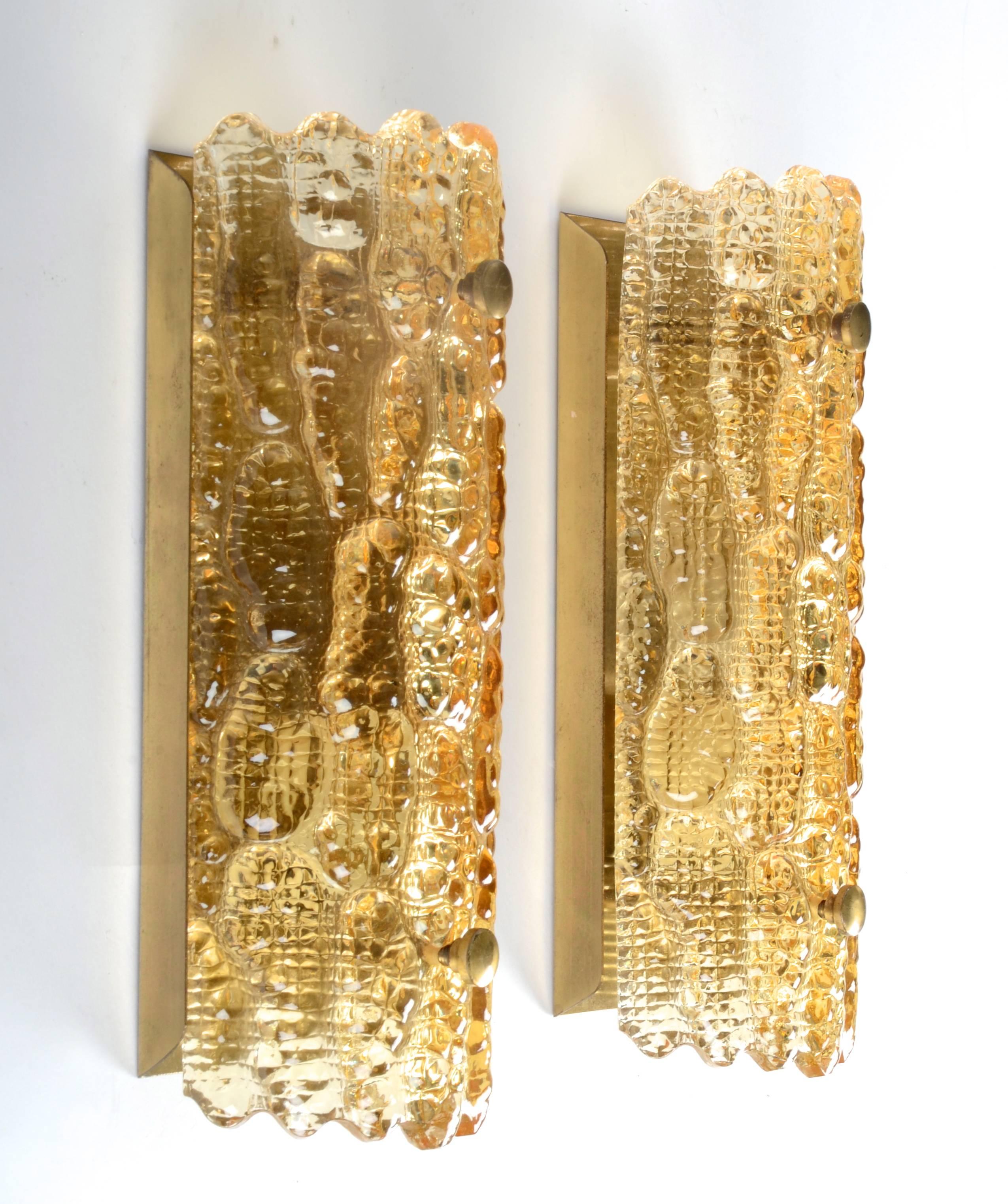 A pair of textured bent glass sconces with brass backplate, by designer Carl Fagerlund for Orrefors.