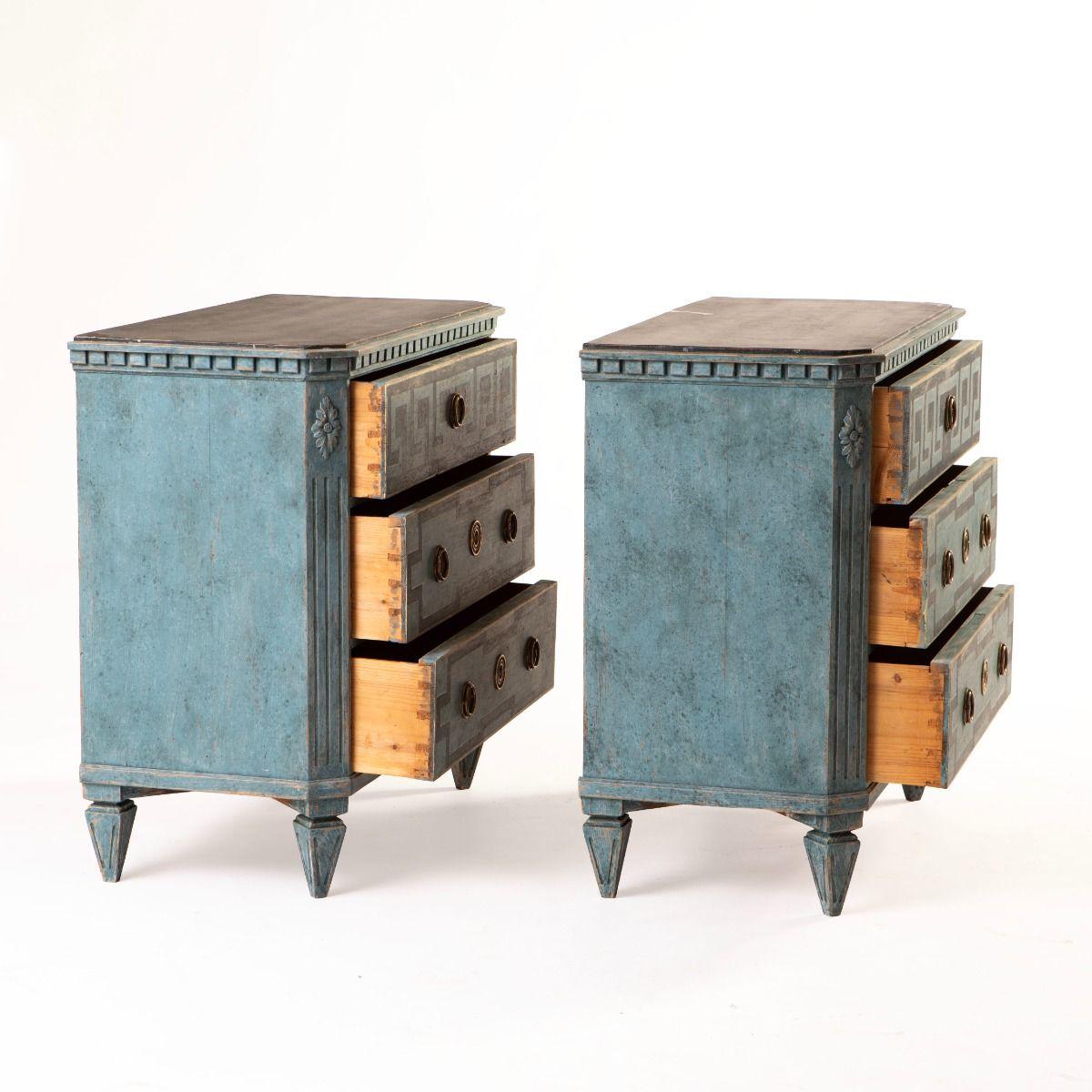 A refined pair of Gustavian-style chests of drawers, crafted in Sweden circa 1840–1860.
Made from pine and painted in a soft blue tone with darker blue geometric detailing. Each chest features three drawers, with the top drawer adorned with a