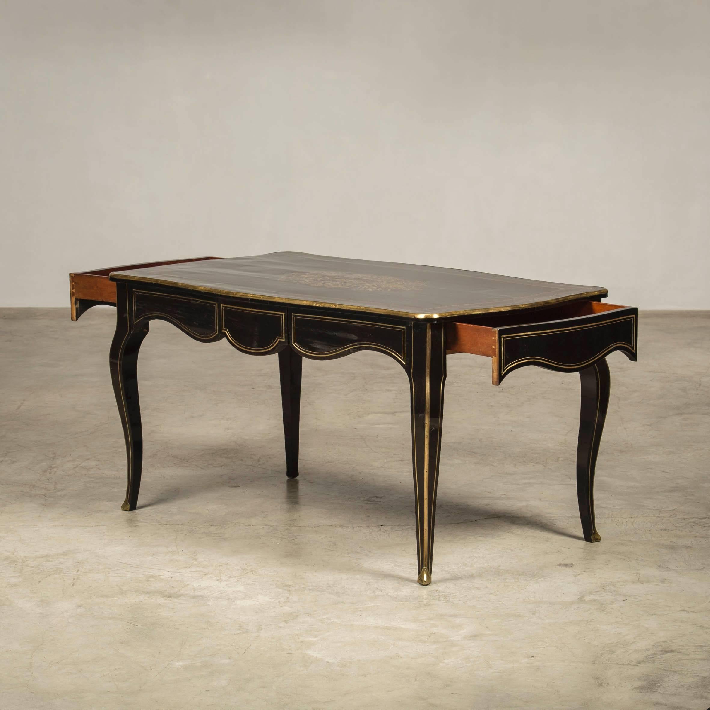 Desk/center table in boulle style, ebonized and ebony veneered wood, richly inlaid with brass, inlays, foliage, etc. Napoleon III, France, circa 1860. Two drawers, one from each side.