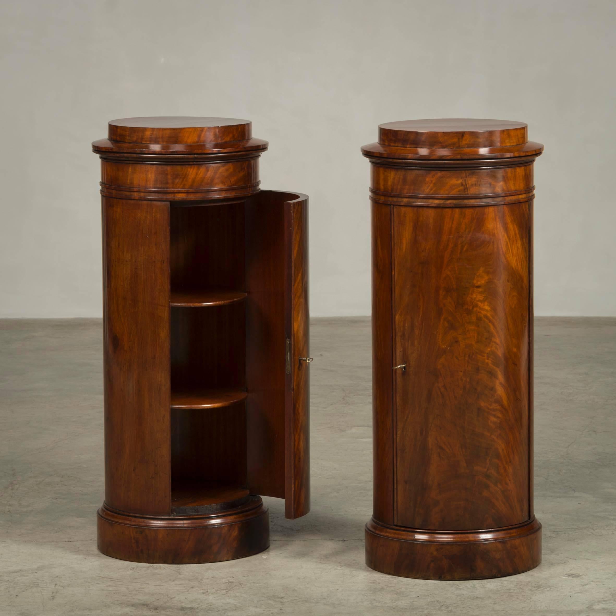 Rare pair of round late Empire pedestal cabinets veneered with flamed Cuban mahogany. Each with a door behind which shelves, 
Copenhagen, 1820-1830. 
Suitable for busts, vases etc.