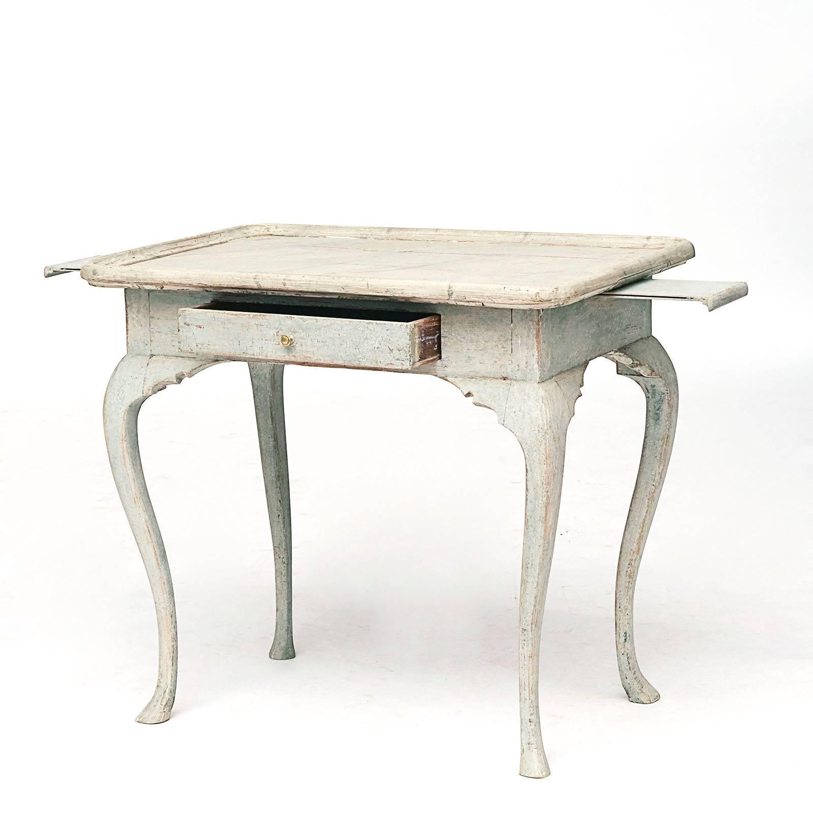 A Danish Rococo painted table, late 18th century, the grey marble painted rectangular top with curved corners and a molded edge above a plain frieze with a single drawer, pull-out candle supports the ends, raised on cabriole legs.