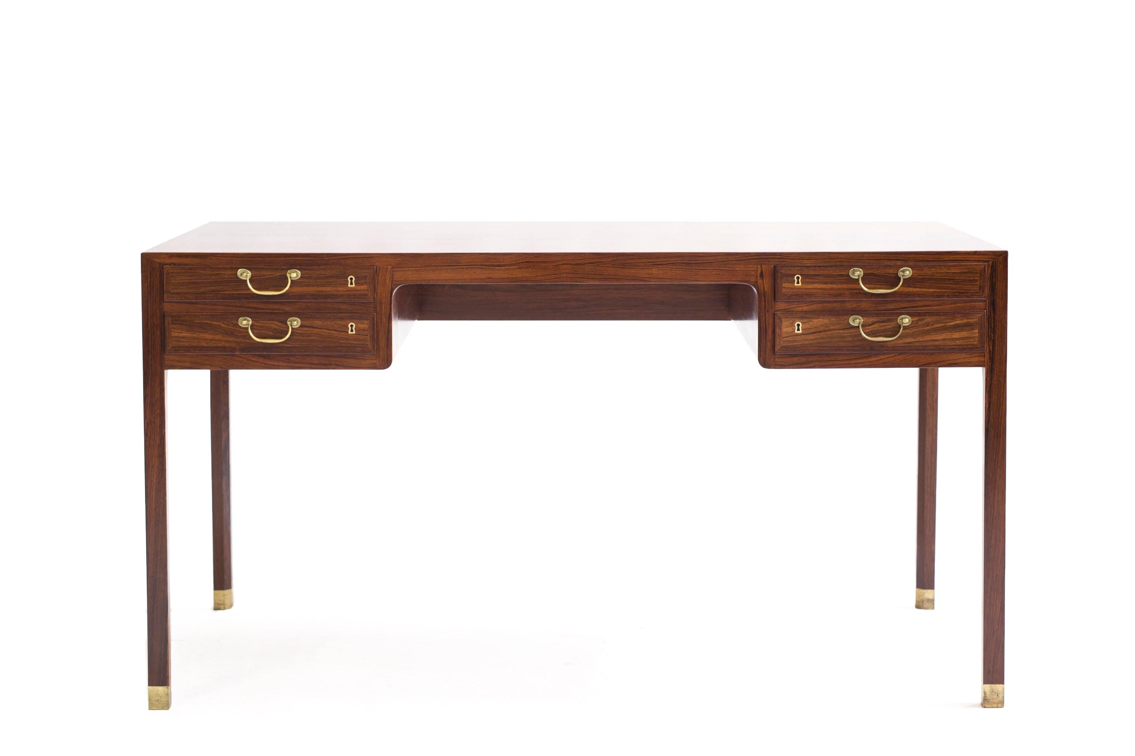 A freestanding Ole Wanscher Brazilian rosewood desk with shoes and handles of brass.

Executed by A. J. Iversen, Denmark.

Very fine condition.