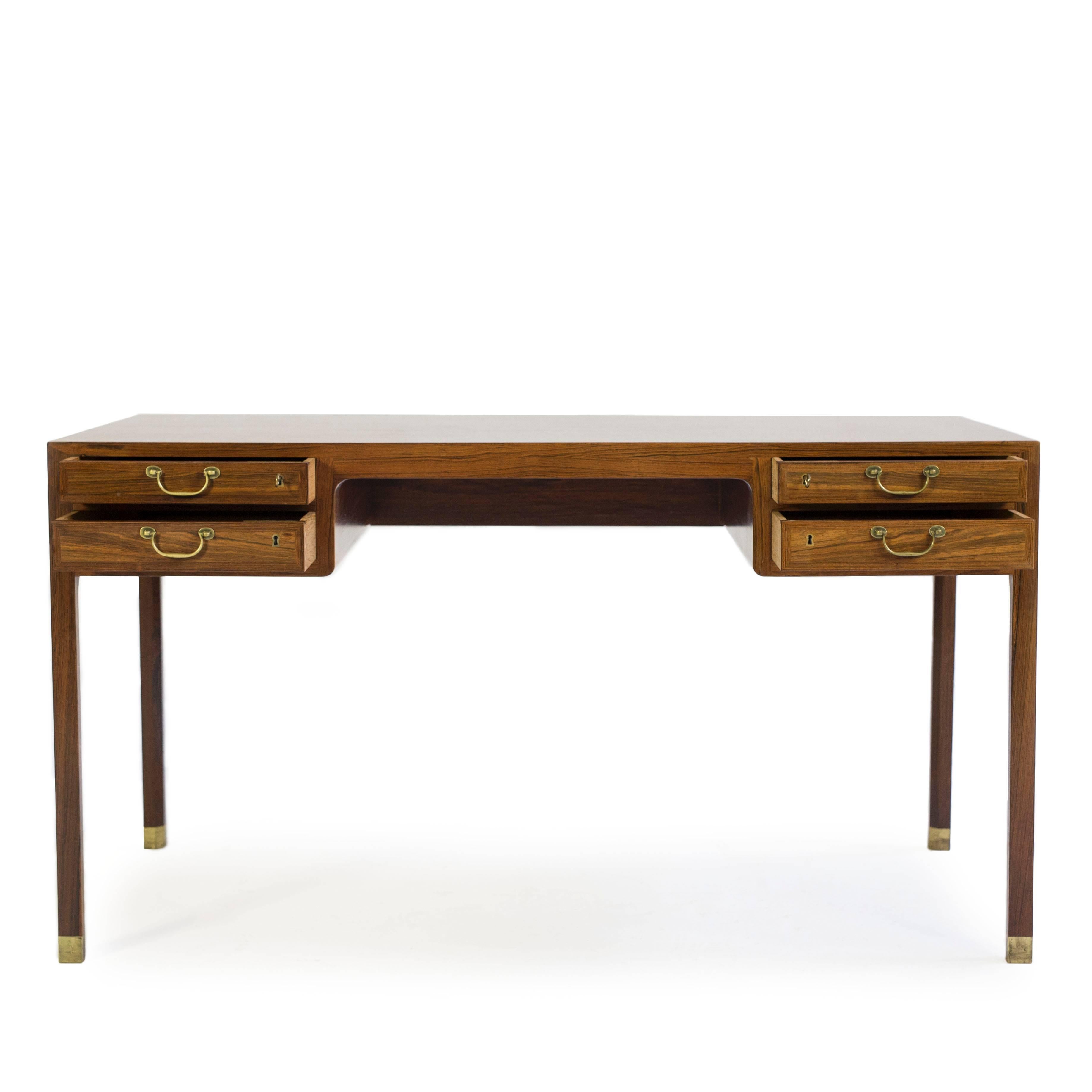 A freestanding Ole Wanscher Brazilian Rosewood desk with shoes and handles of brass. 

Executed by A. J. Iversen, Denmark 

Very fine condition.  
