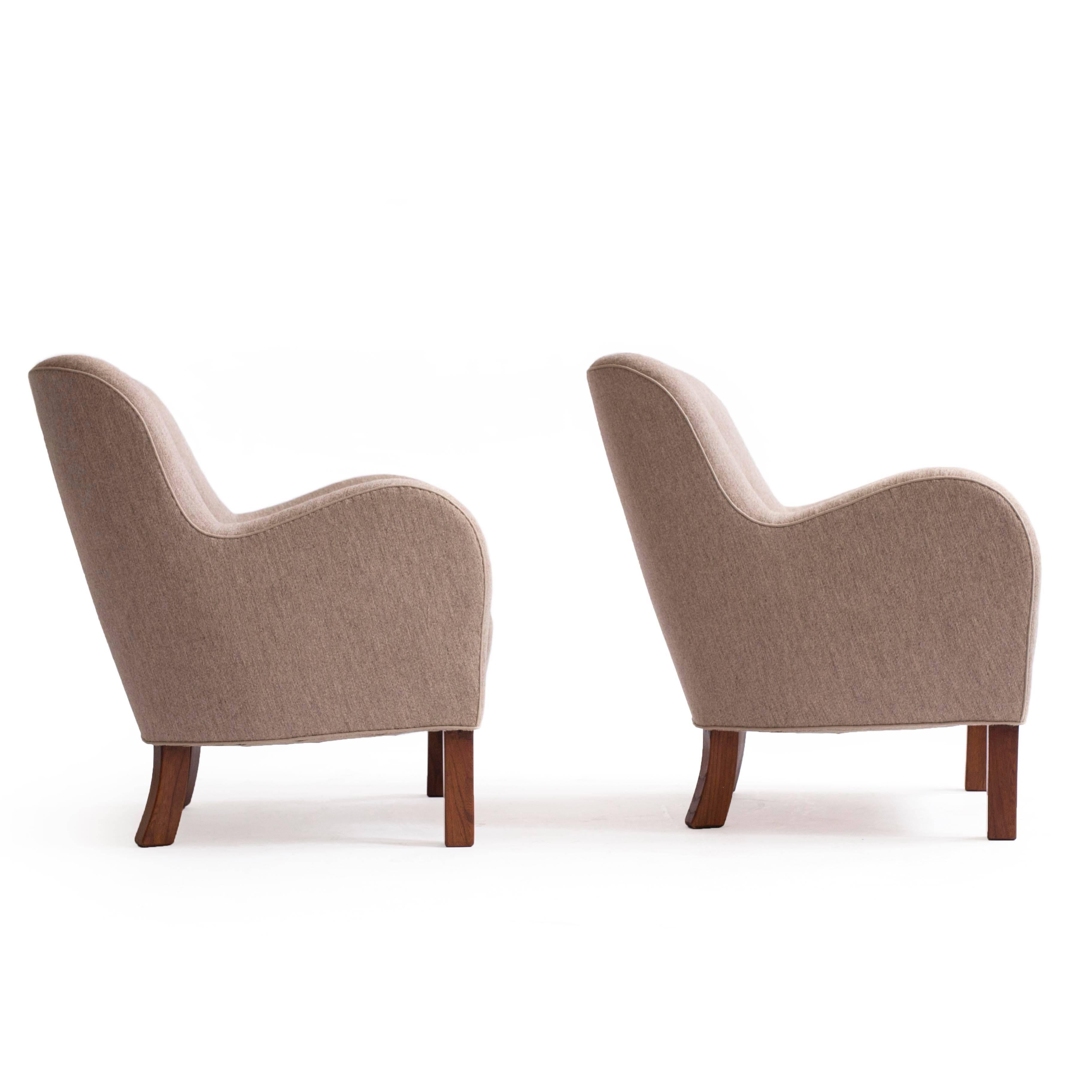 A pair of Palle Suenson easy chairs with legs of stained wood, upholstered with soft brown savak fabric fitted with buttons. 

Designed by Suenson and made by Fritz Hansen, Denmark app. 1935.
