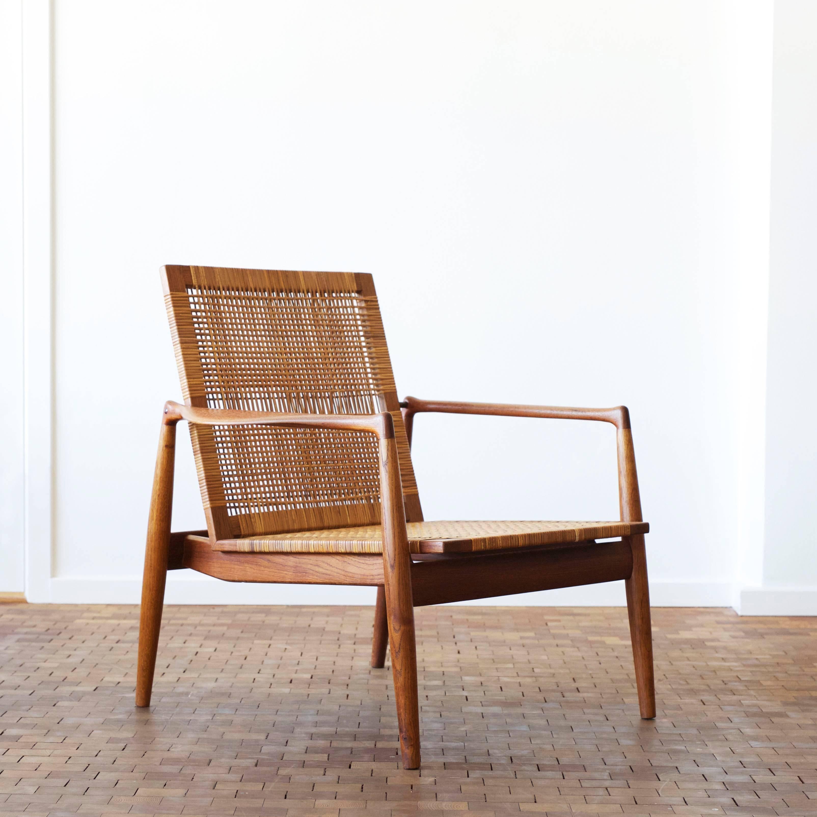 Beautiful Finn Juhl easy chair with frame of original patinated oak, arms of teak, back and seat upholstered with woven cane.

Designed by Finn Juhl 1954, manufactured by Søren Willadsen, Denmark 1950s, model SW96. Executed in limited