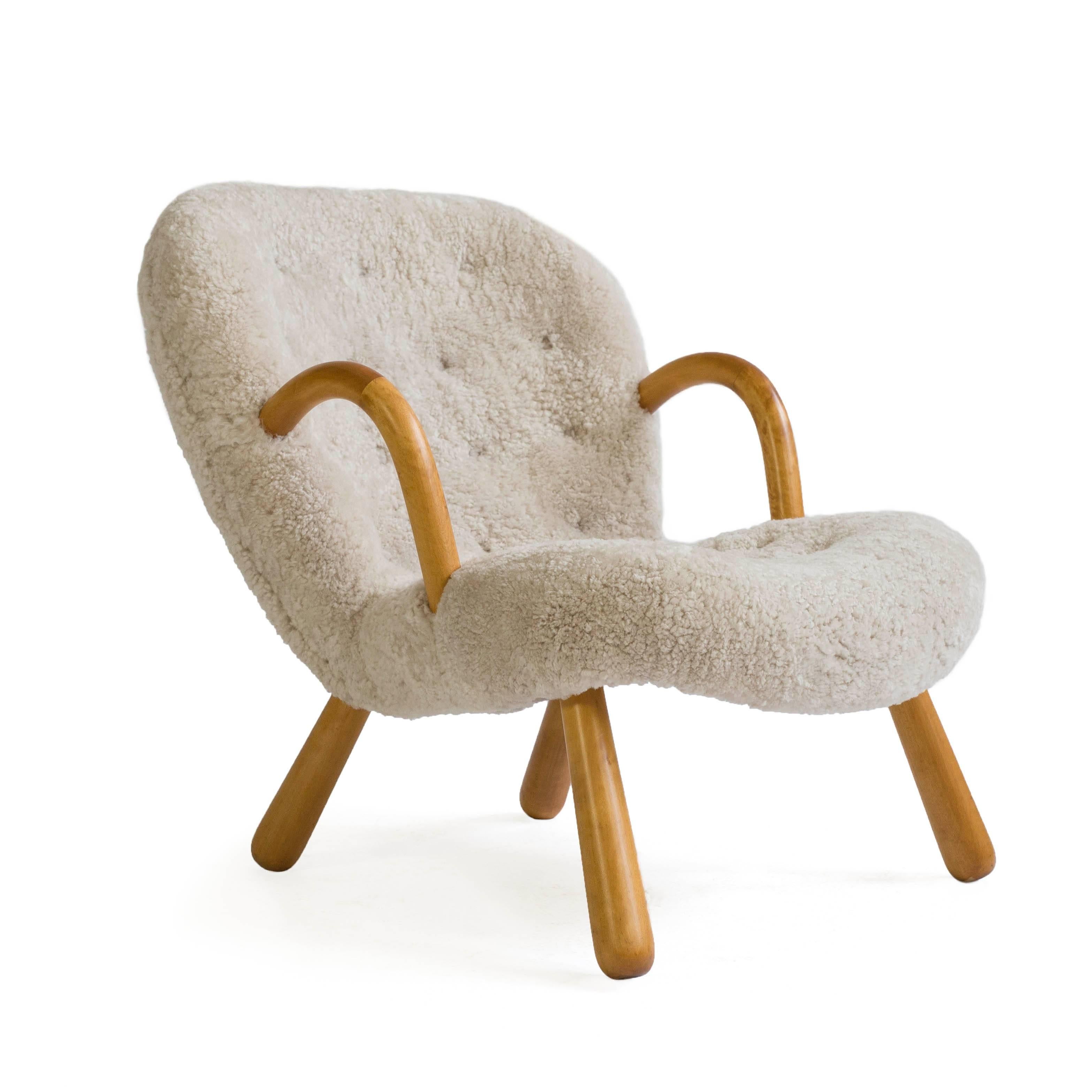 A Philip Arctander clam chair with legs of birch upholstered with sheep skin. 

Designed by Philip Arctander, Denmark 1944 and manufactured by Nordisk Stål & Møbel Central, Denmark.