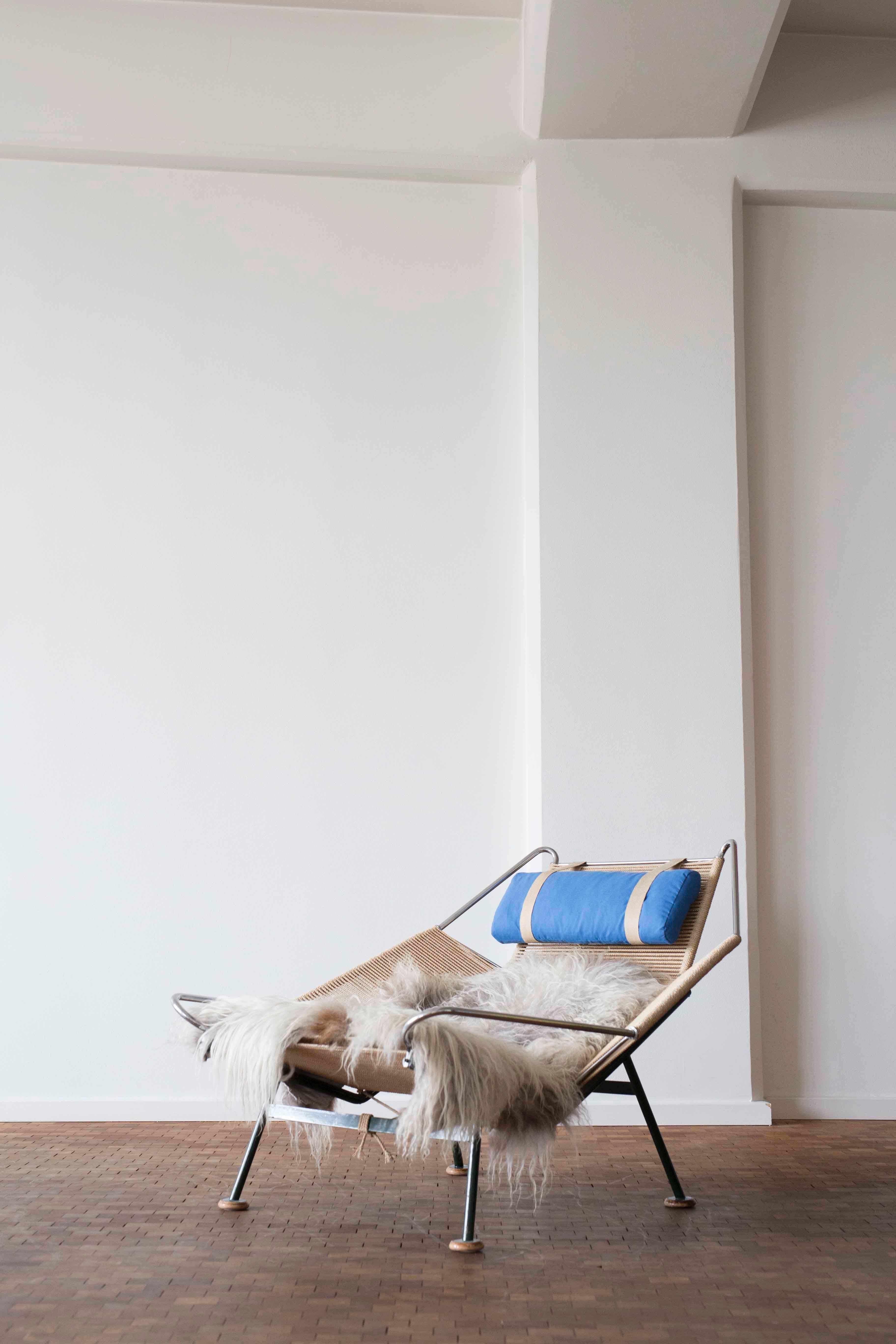 Hans J. Wegner flag Halyard easy chair with original green steel frame, wooden beech shoes and blue neck cushion. 

Designed by Hans J. Wegner in 1950 and manufactured by Getama, Denmark, model GE225, early 1950s. 
