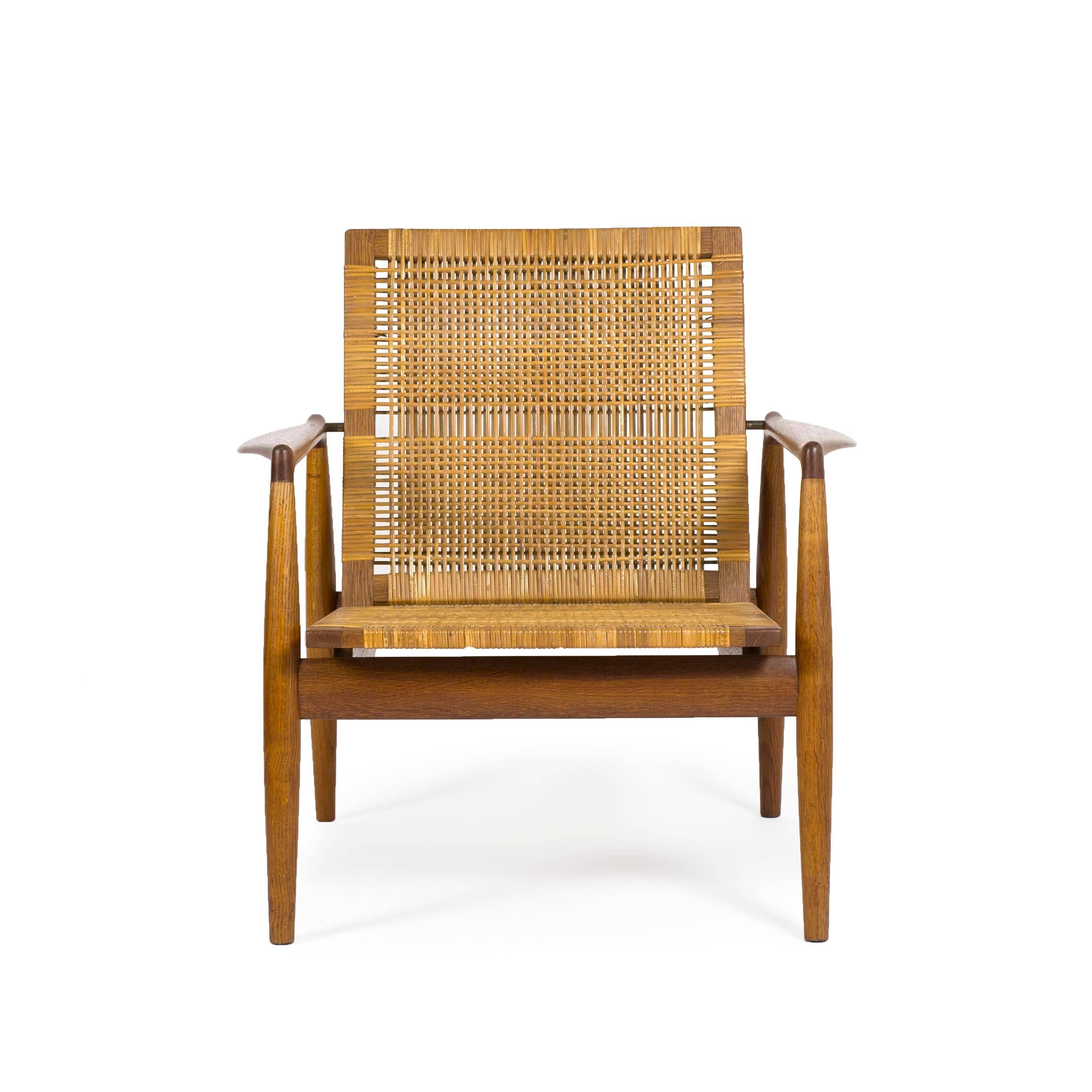 Finn Juhl easy chair with frame of original patinated oak, arms of teak, back and seat upholstered with woven cane. 

Designed by Finn Juhl 1954, manufactured by Søren Willadsen, Denmark 1950s, model SW96. Executed in a limited number. 

Very