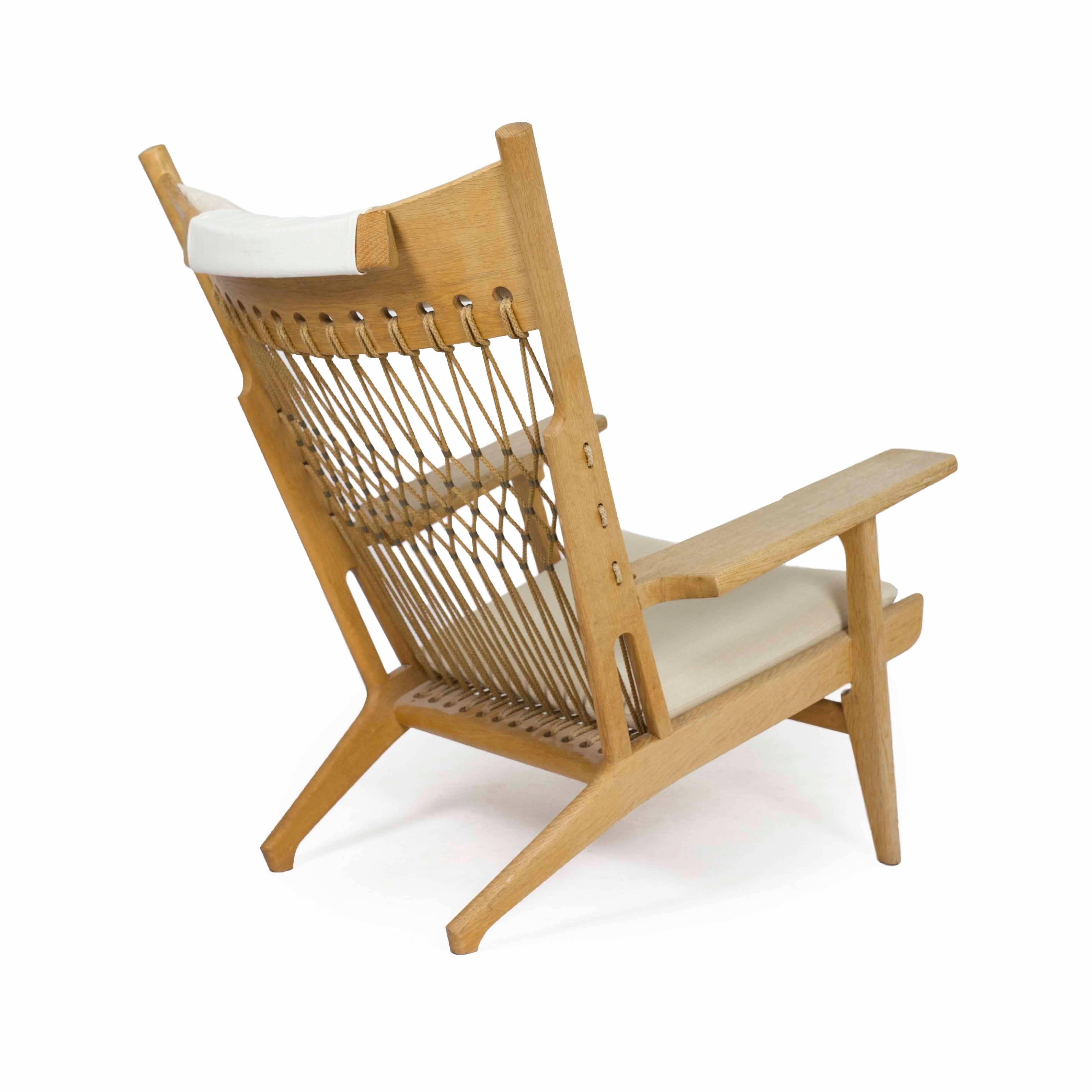 Rare Hans J. Wegner oak armchair model JH-719. 

Designed 1968 and made by cabinetmaker Johannes Hansen. 

Frame of oak, seat and back with woven halyard and brass details. Seat and head cushions upholstered with light fabric. 

Very fine
