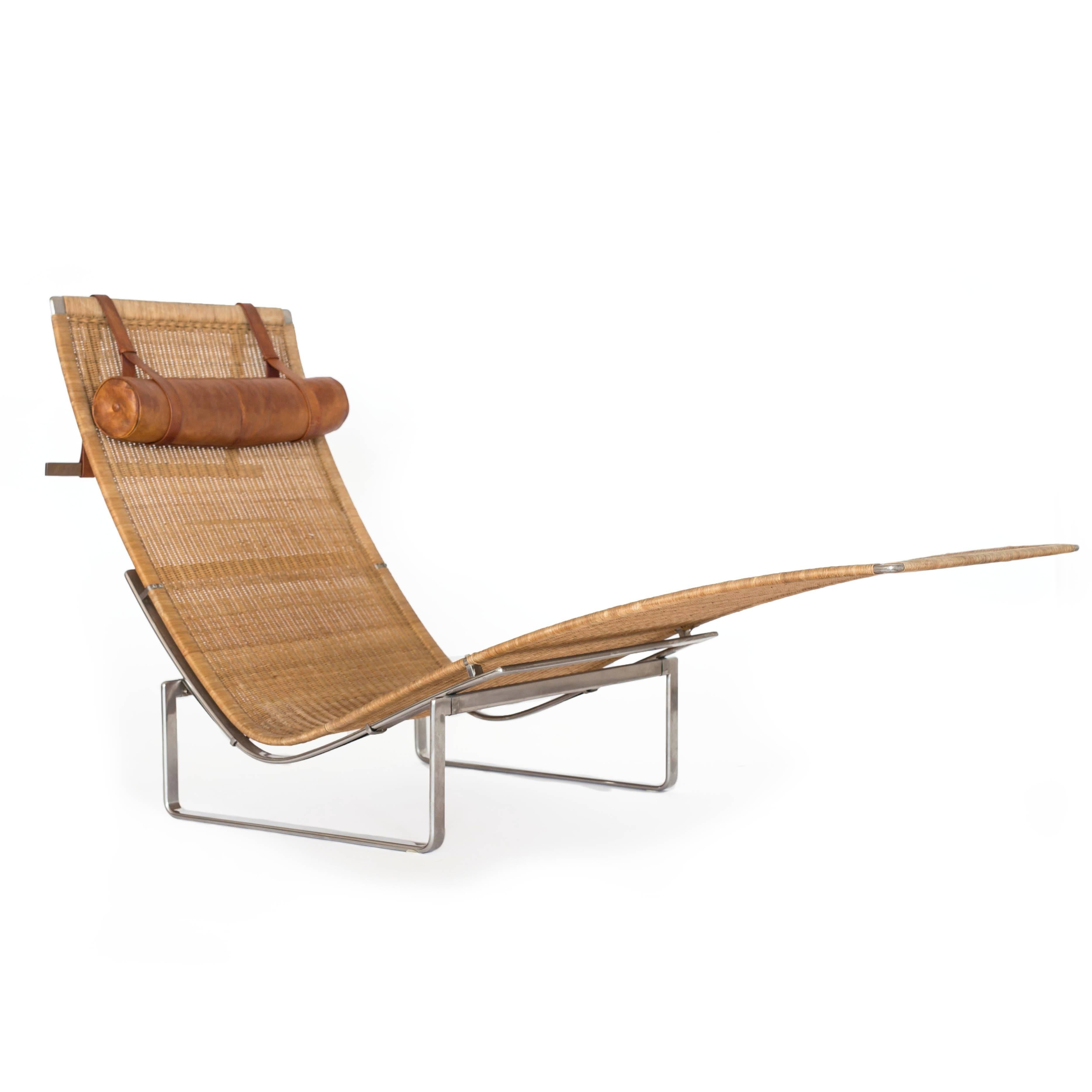 Poul Kjærholm PK-24 chaise longue with stainless steel frame, woven cane and headrest upholstered with original patinated Nigerian leather. 

Designed 1965, made at E. Kold Christensen, Denmark, 1960s. 
Beautiful original condition.