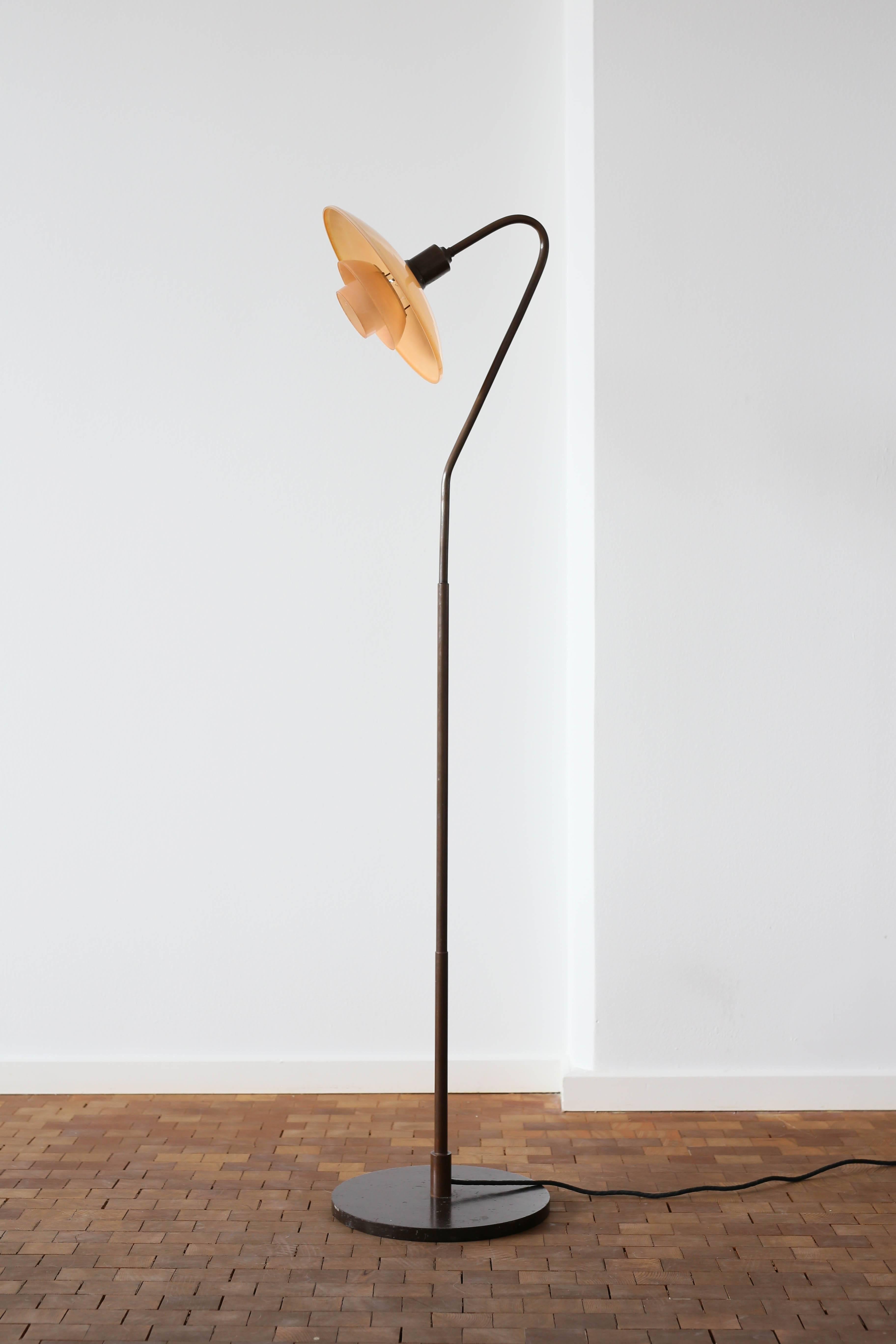 Poul Henningsen standard floor lamp. 

Rare and early edition with large stand in three levels and socket house of browned brass. Original 3/2 red opal glass. 

Designed and made by Louis Poulsen, Denmark, 1931. Stamped 'Patended'. 

Very fine