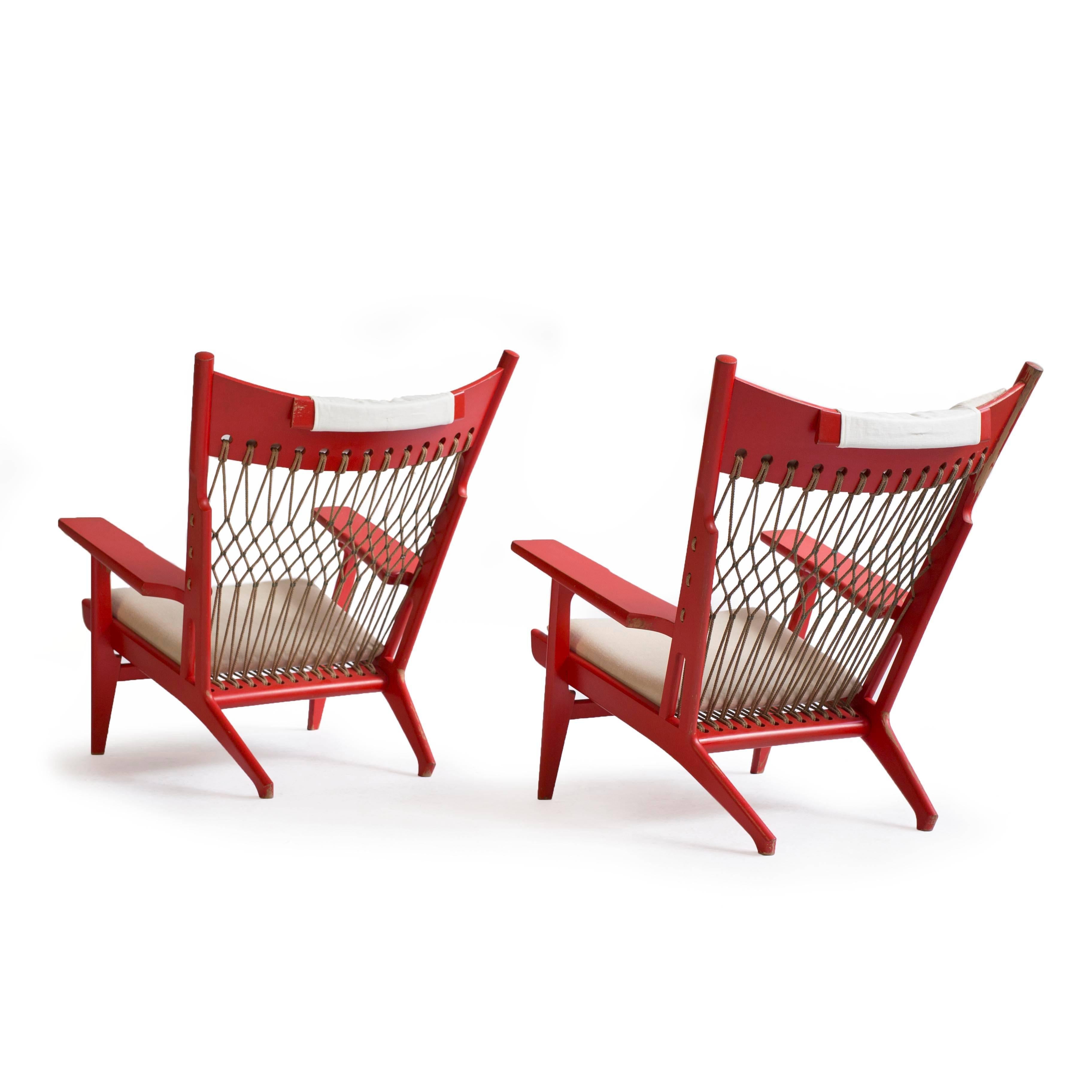 A pair of very rare Hans J. Wegner JH-719 lounge chairs.

Priced and sold individually. 

Designed 1968 and made by cabinetmaker Johannes Hansen.
Frame of red lacquered wood, seat and back of woven flag halyard and brass assemblings. Seat and head