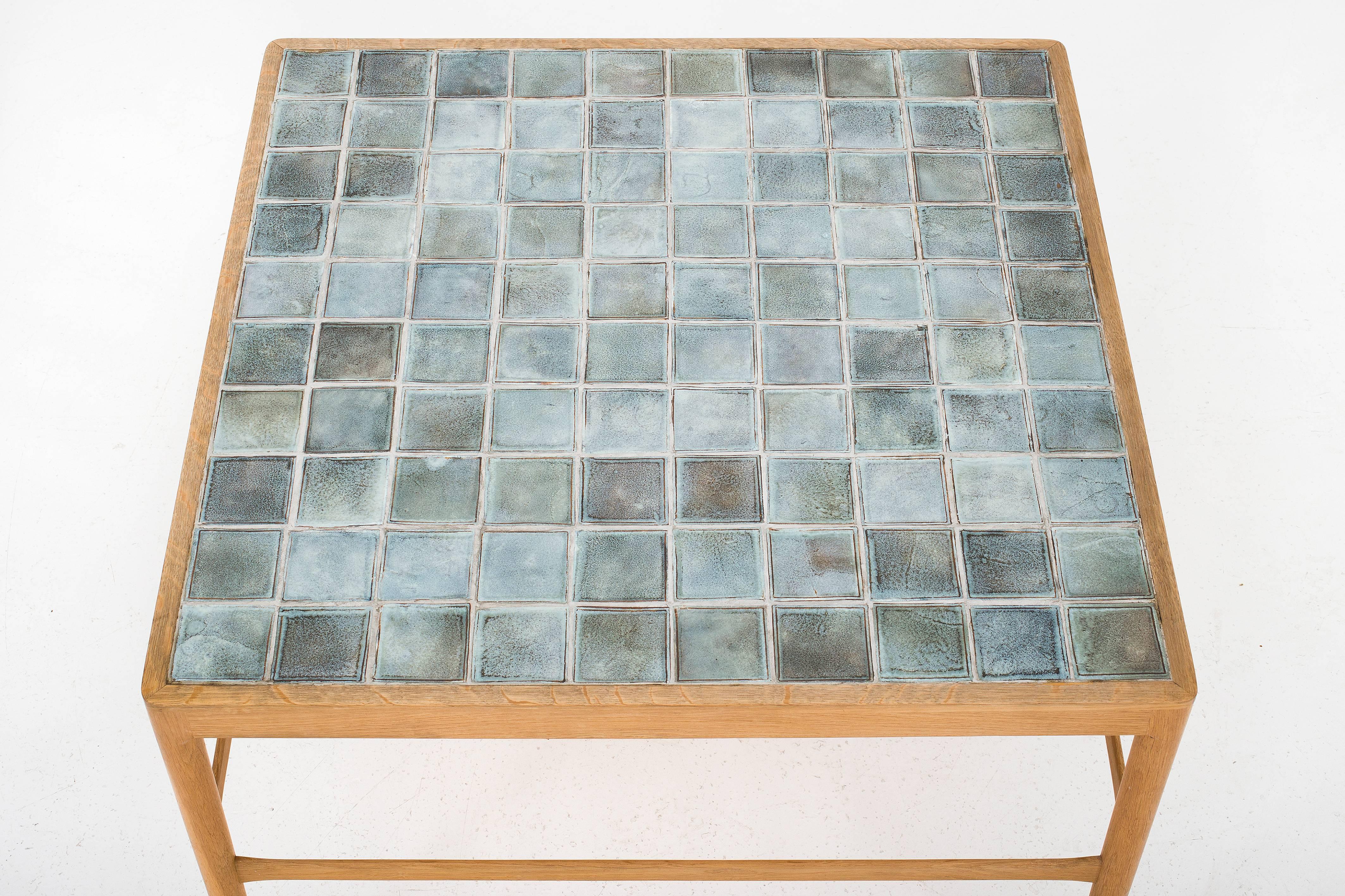 Coffee table in oak with green or blue tiles.