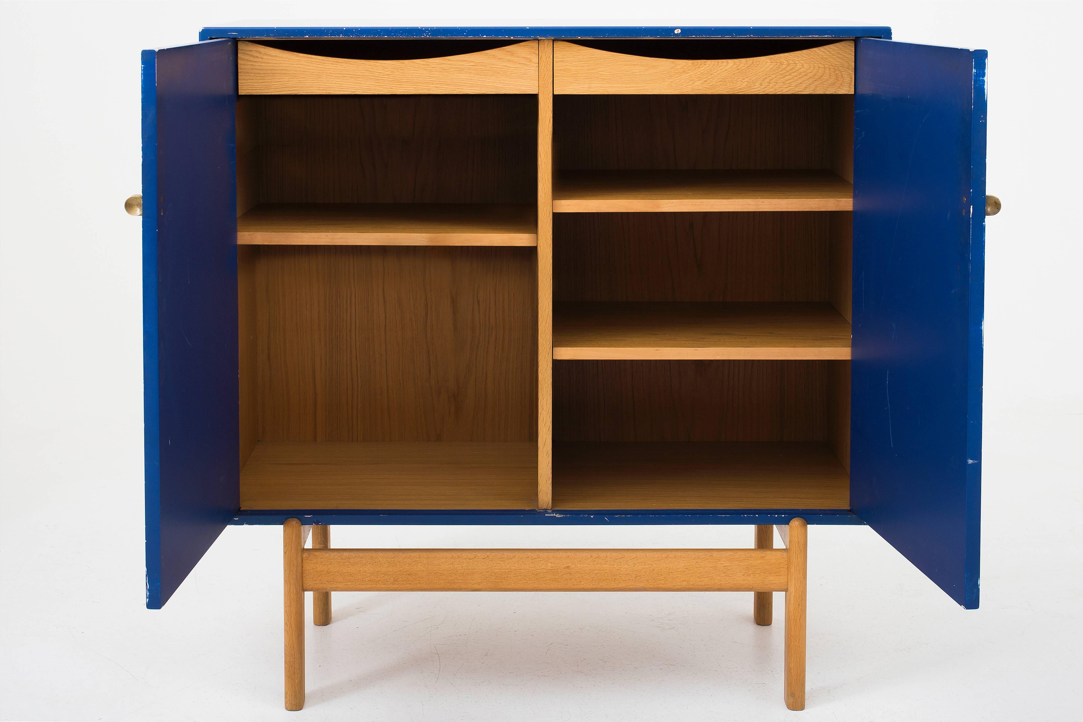 Cabinet designed by Tove and Edvard Kindt-Larsen. Cabinet in blue lacquered oak, legs in oak and handles in brass. Maker Säfle, Sweden, 1960.