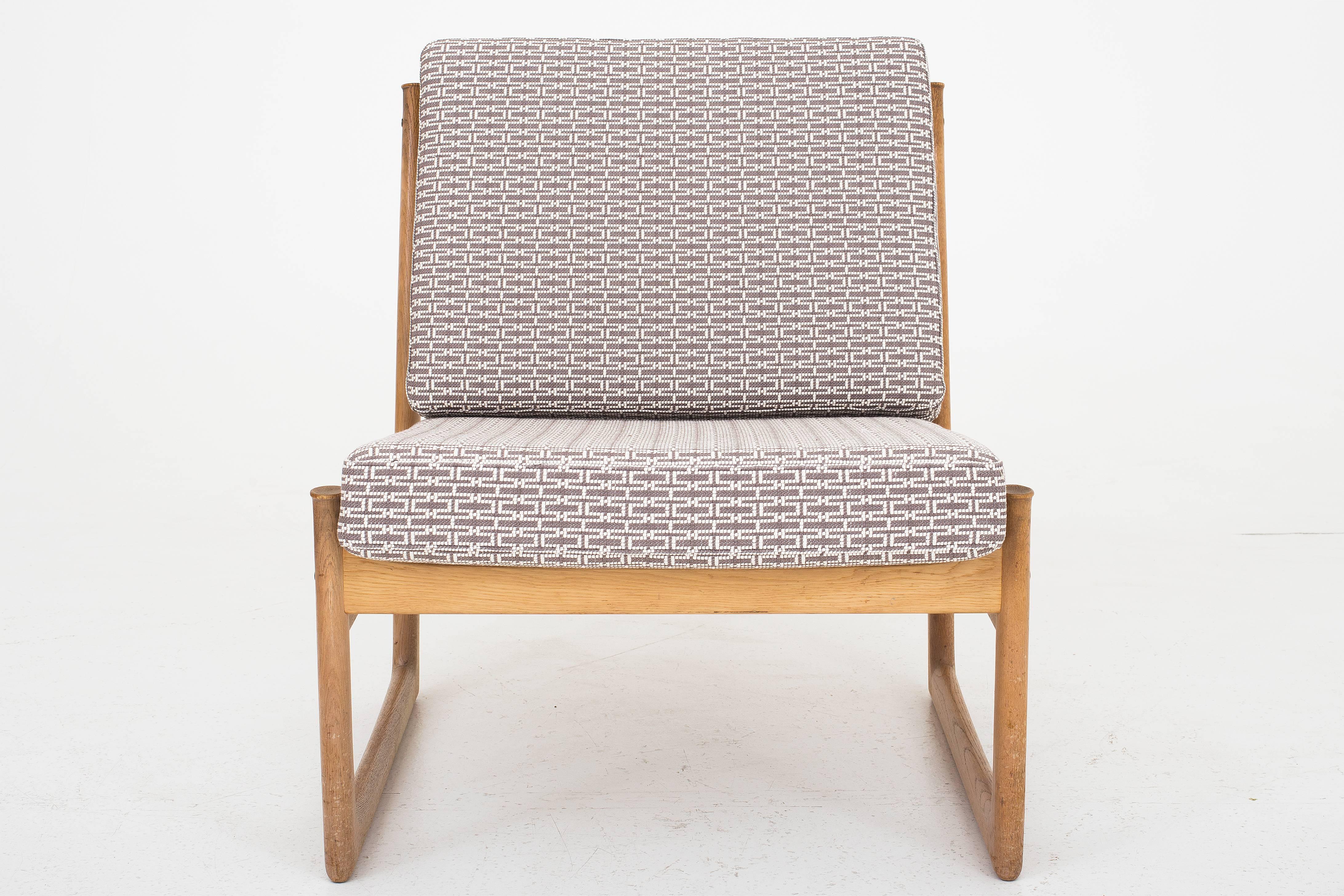 A pair of lounge chairs designed by Peter Hvidt and Orla Mølgaard Nielsen in oak and reupholstred in Hermes, Metallerie col. M02. Maker France & Son.