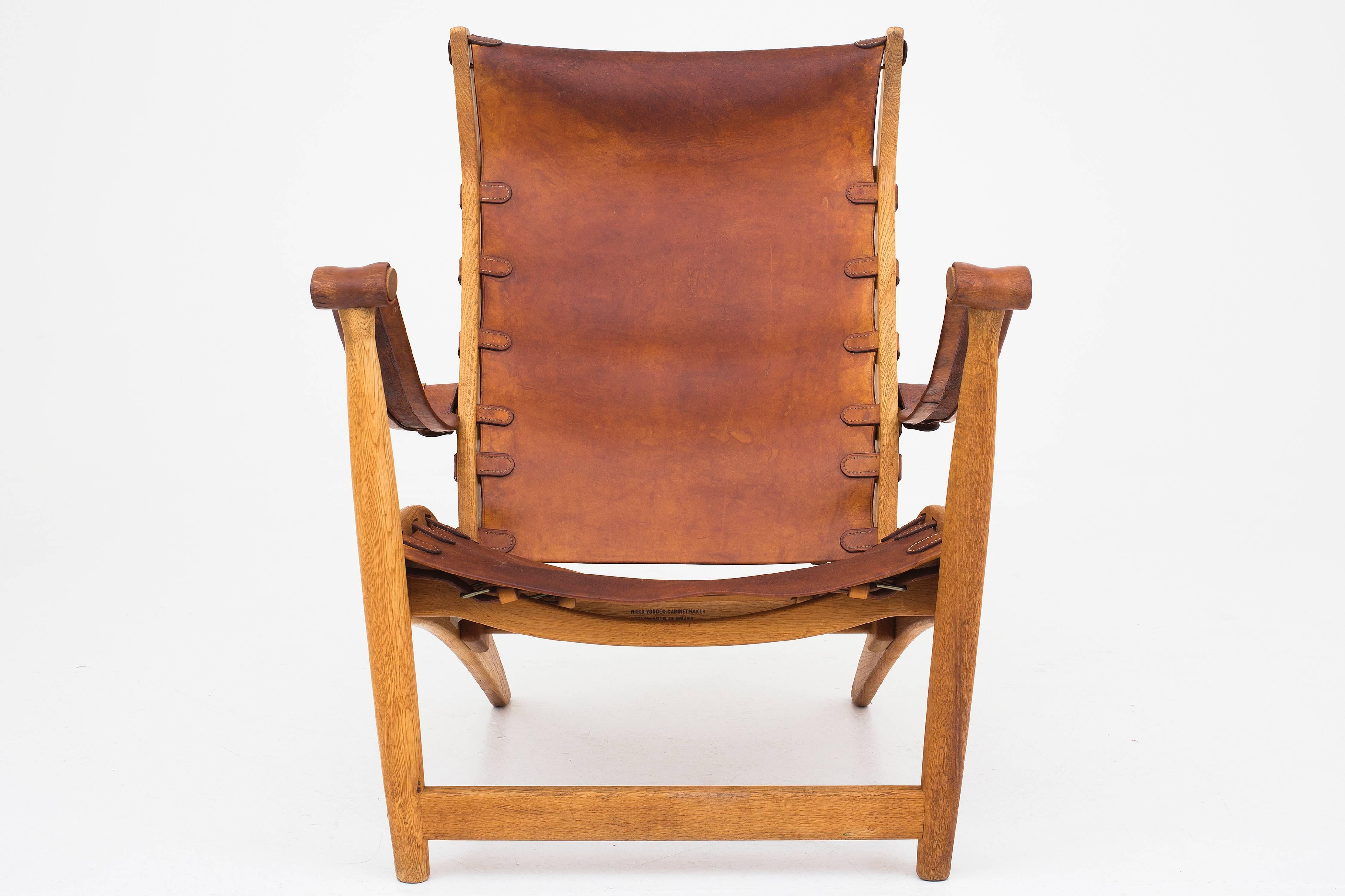 A pair of easy chairs in oak and original patinated leather model MV60. Designed by Mogens Voltelen and maker Niels Vodder.