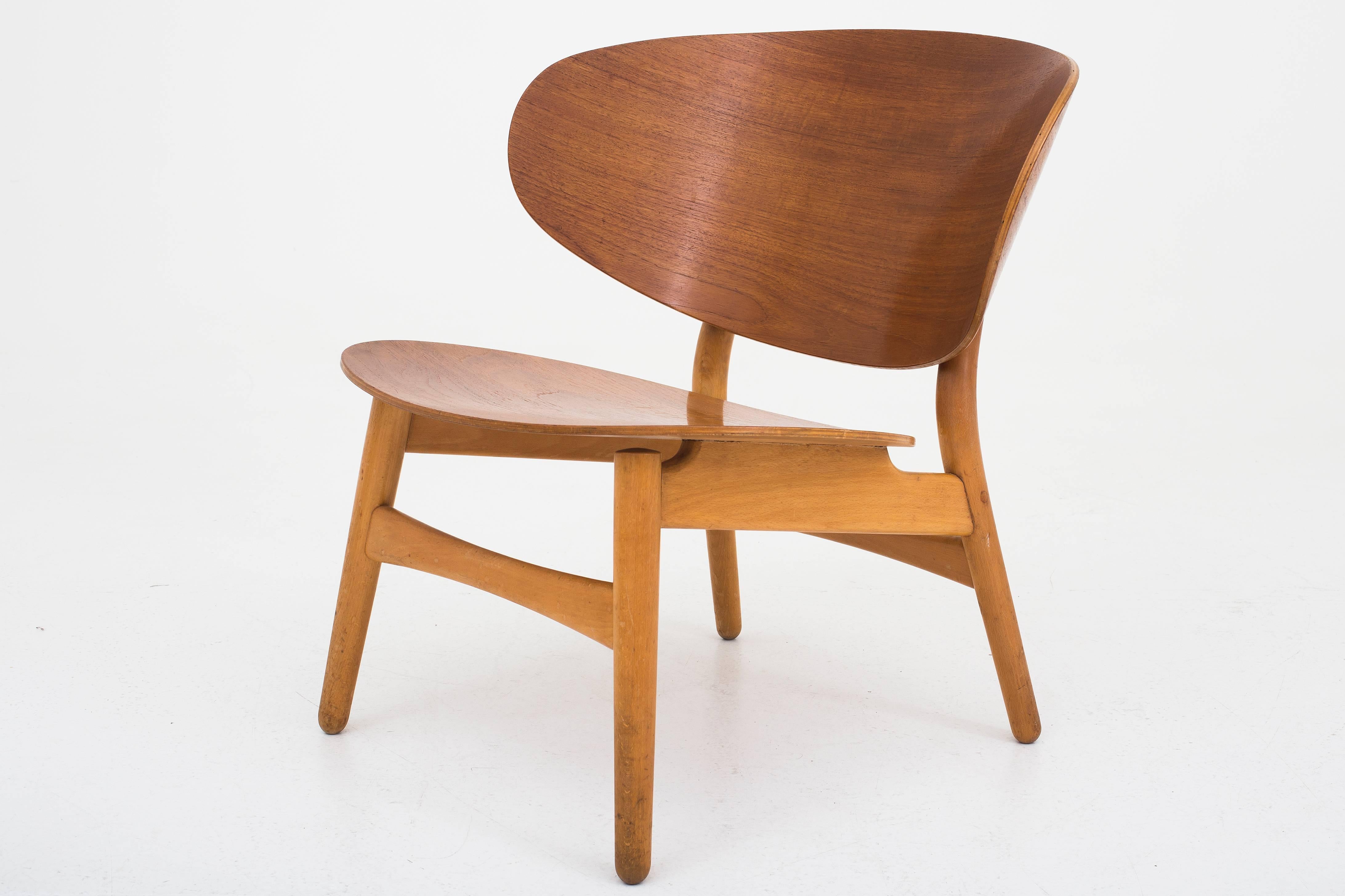 Shell chair in laminated teak and beech designed by Hans J. Wegner. Maker Fritz Hansen.