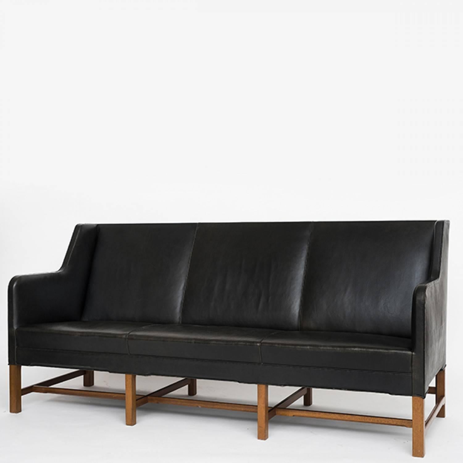 Kaare Klint sofa with original black leather and legs in mahogany. Maker Rud Rasmussen.