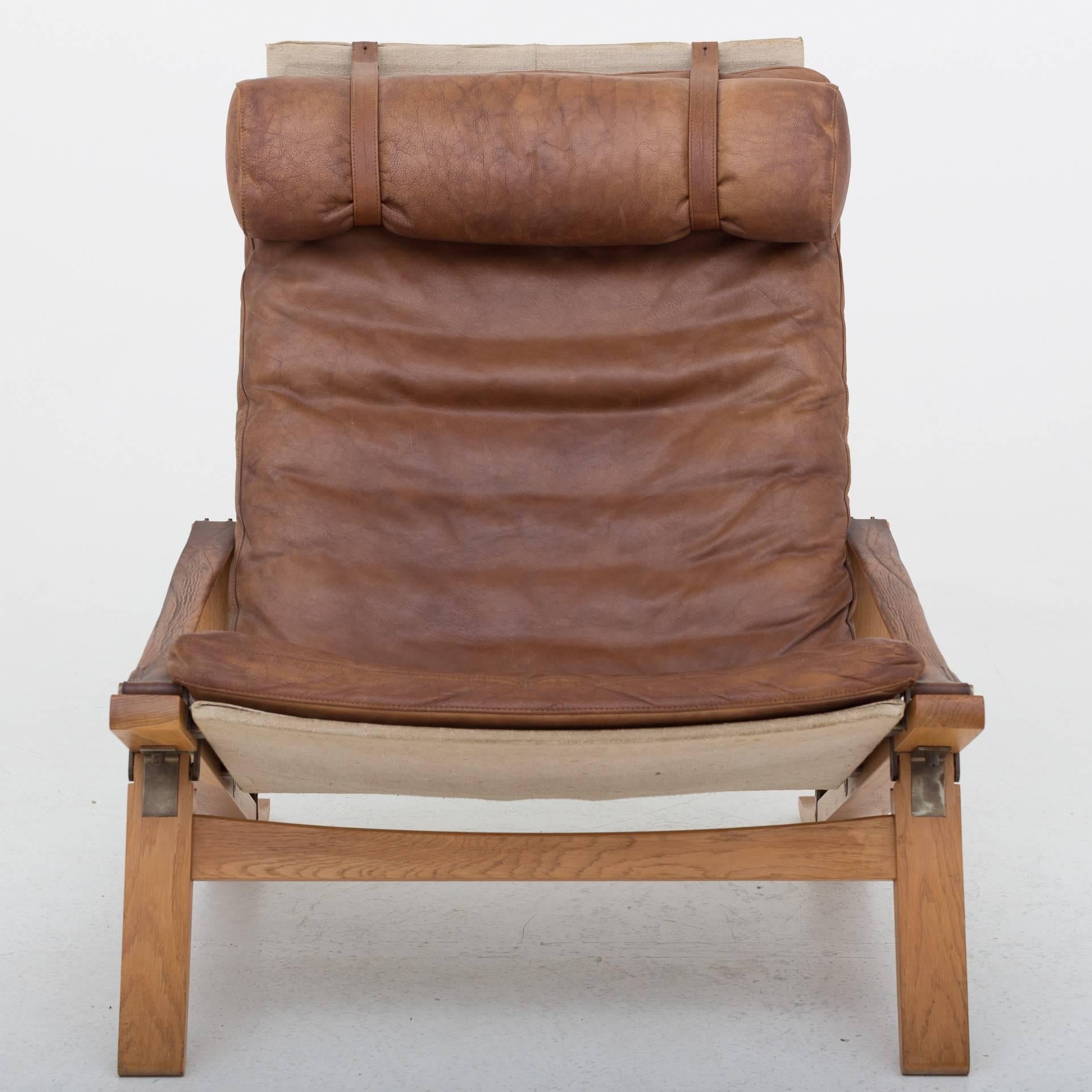 A pair of lounge chairs, model PB 10 in oak, patinated brown leather and canvas. Designed by Preben Fabricius & Jørgen Kastholm.