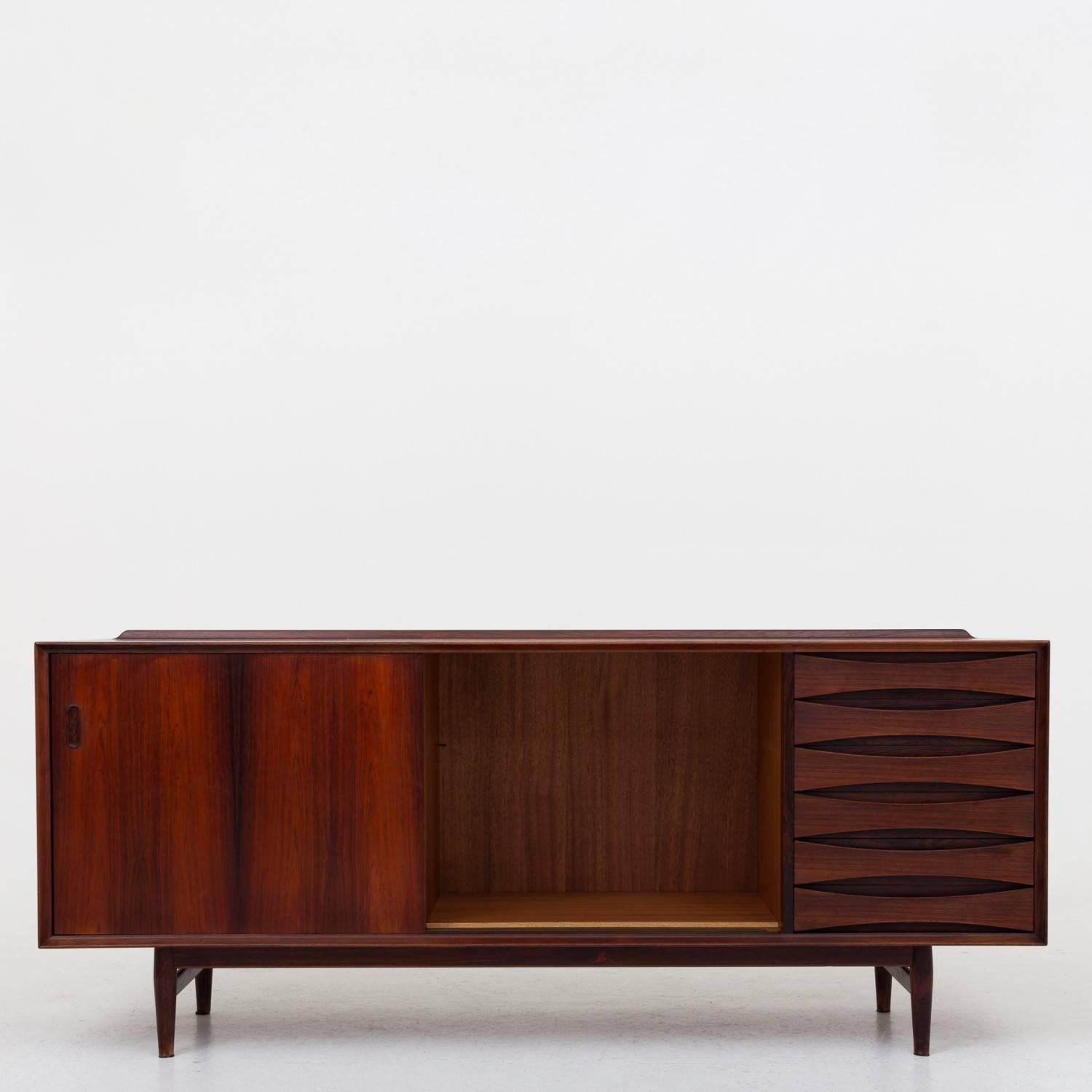 Sideboard in rosewood, front with drawers and sliding doors, inside shelves. Designed by Arne Vodder. Maker Sibast Møbler.