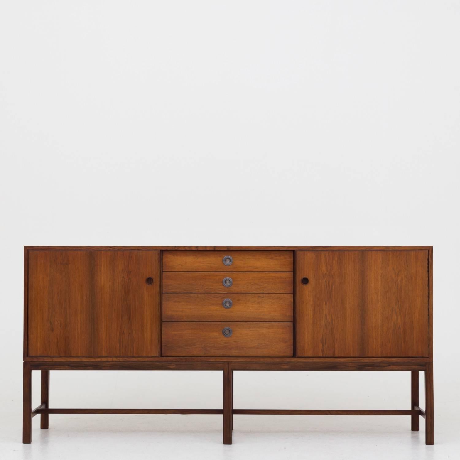 Sideboard in rosewood by Danish cabinetmaker, front with four drawers and metal handles.
 