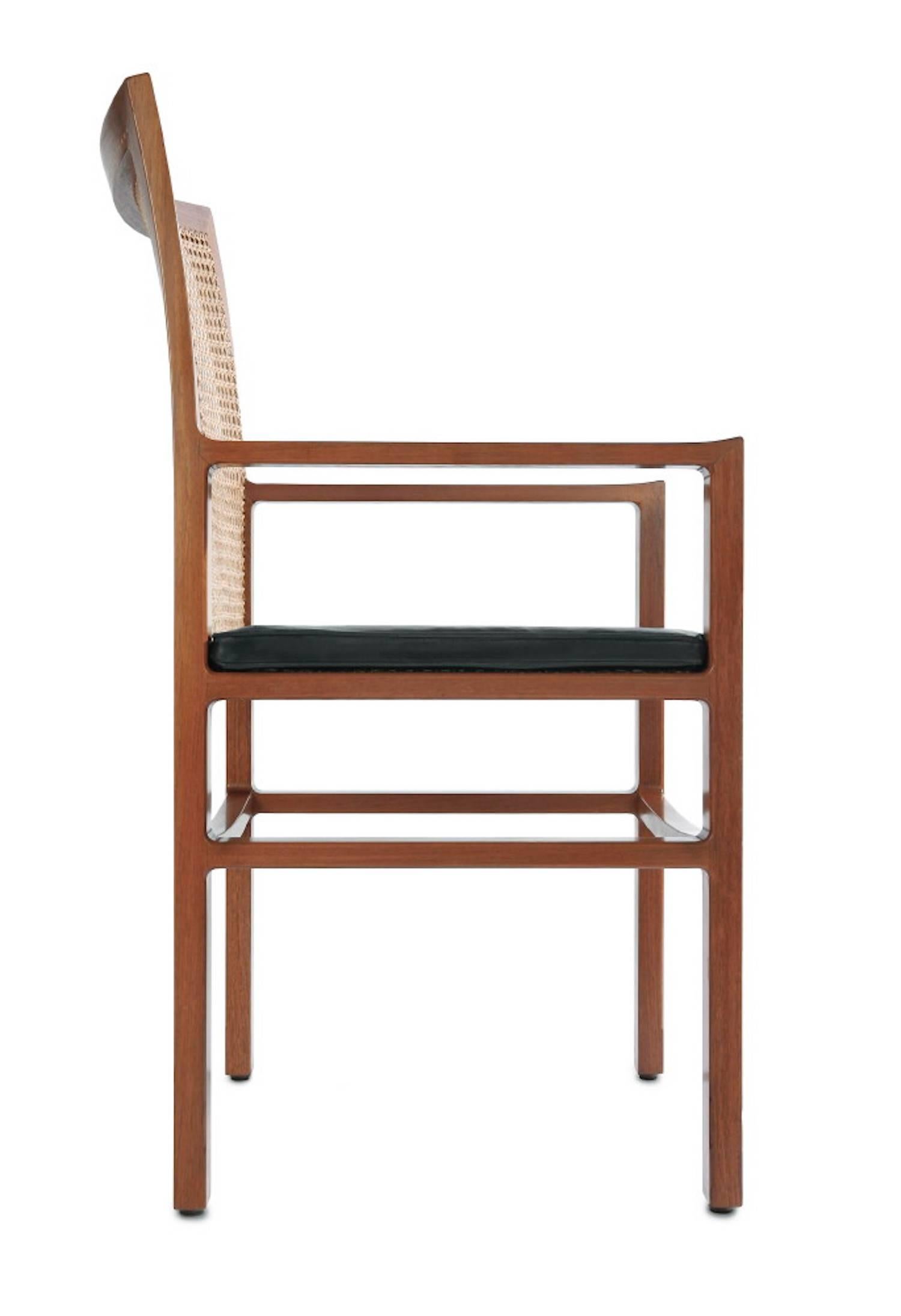 Armchair of mahogany with black leather seat, back of woven cane. Designed in 1965, manufactured by Michael Bloch.