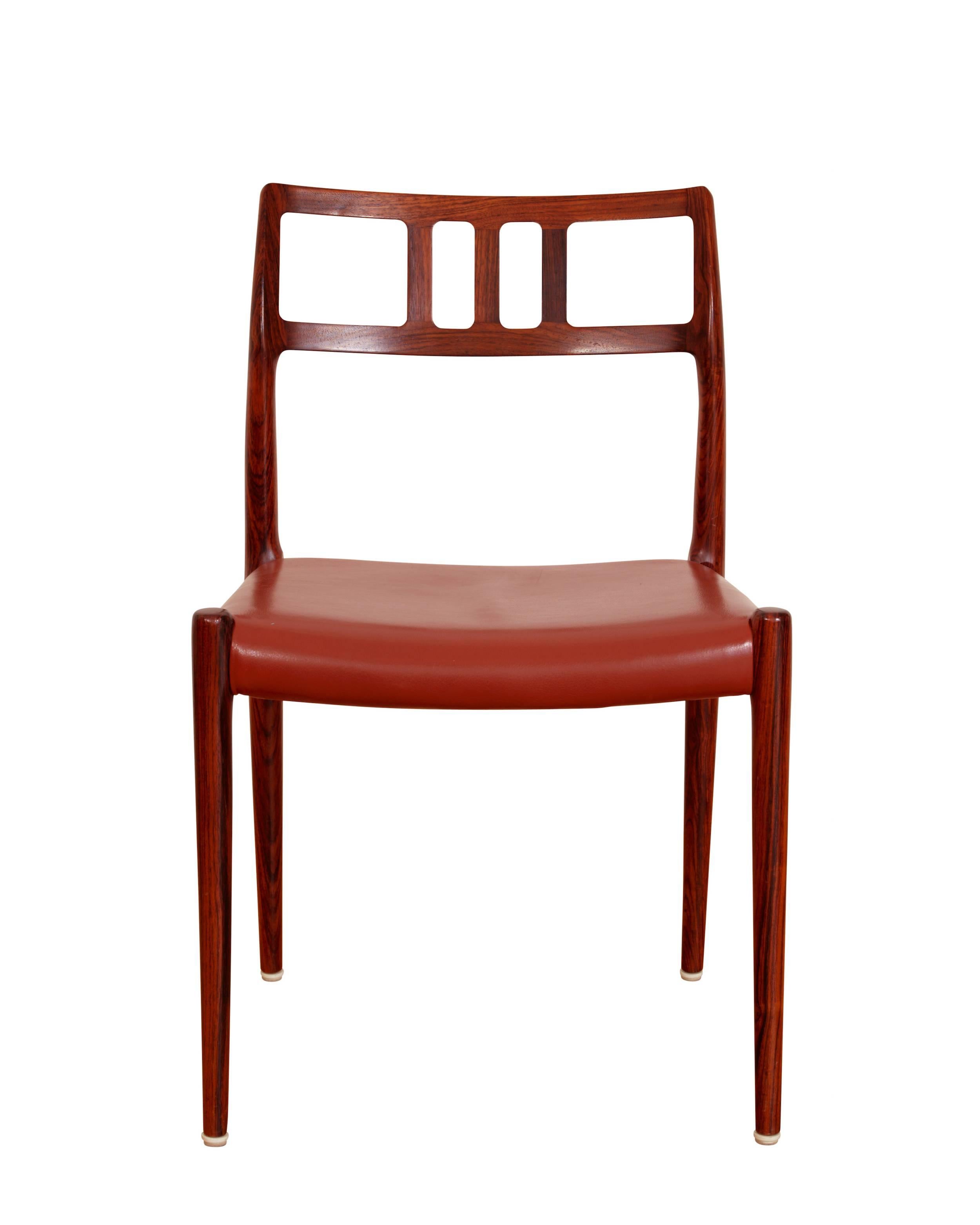 A set of six dining room chairs of rosewood, upholstered with red leather.
Manufactured by J. L. Møller.