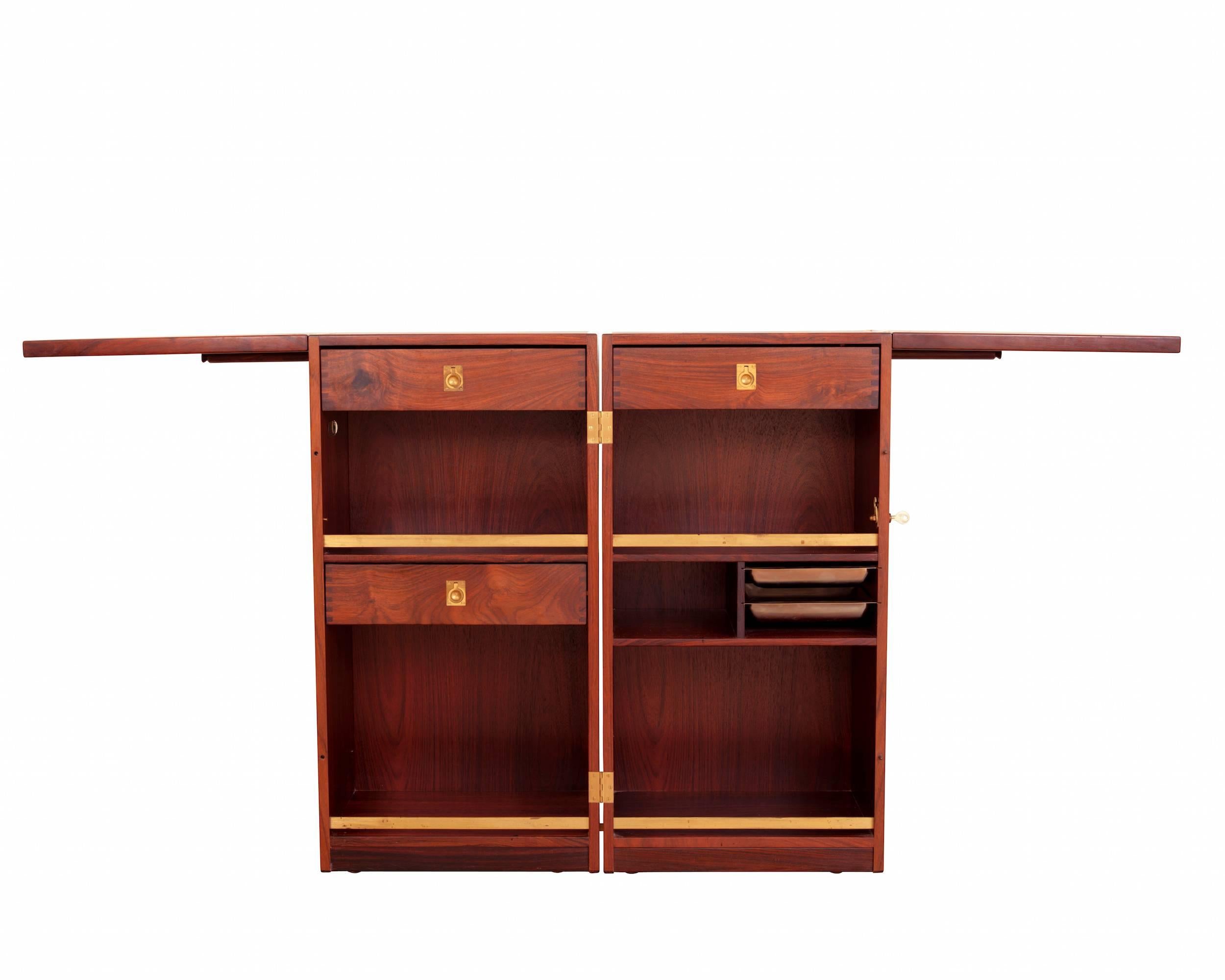 Rosewood bar on wheels with drawers with brass fittings and unfolding table tops with black formica. 
Measurements are taken when the bar is closed completely.