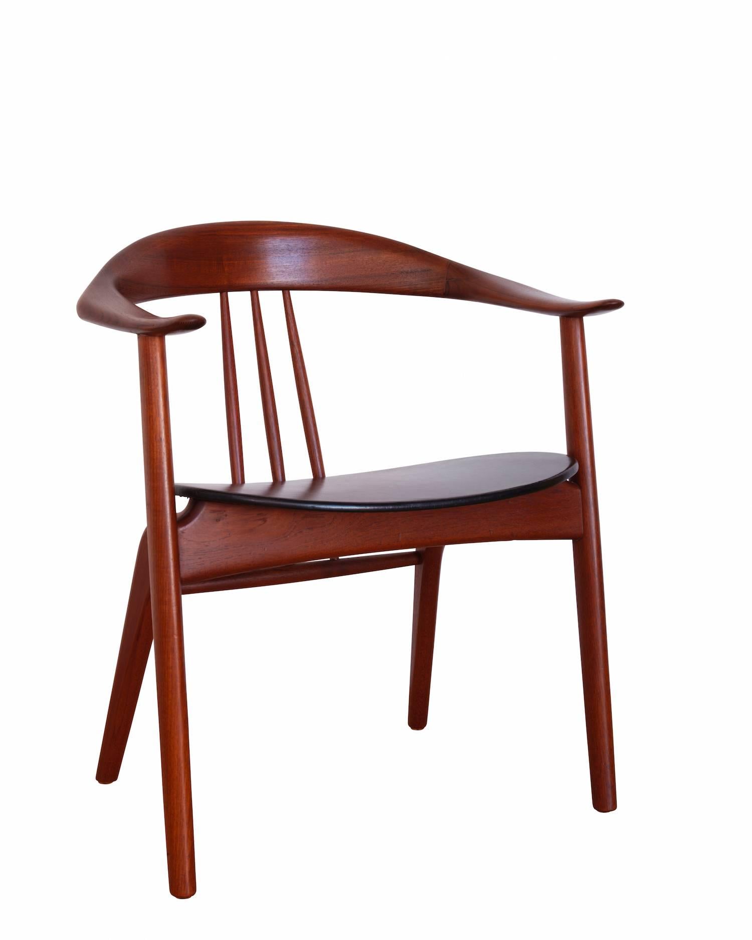 Teak armchair with black leather seat. 
Manufactured by Mogens Kold in the 1950s.