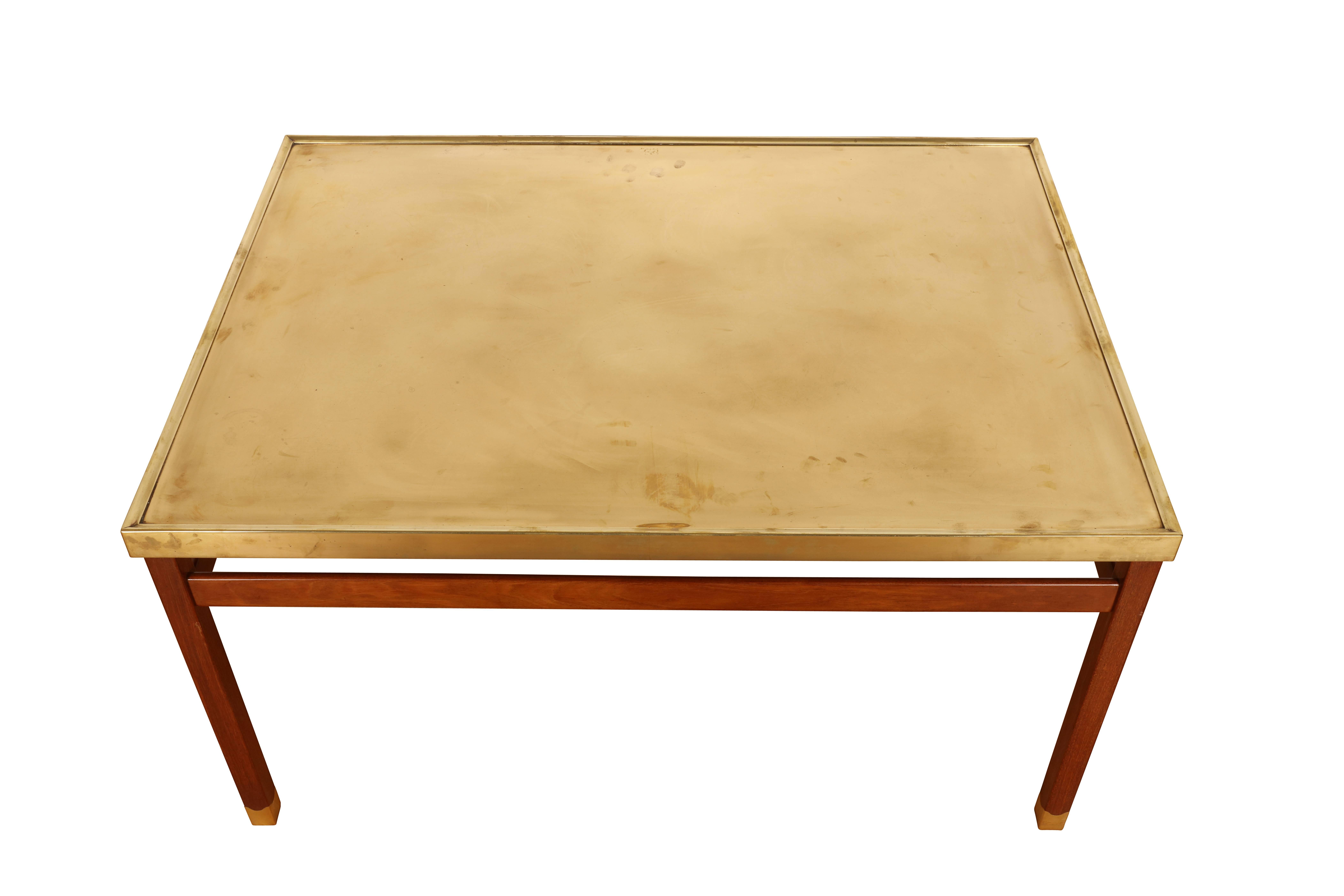 Unique rectangular coffee table. Brass top with moulded edges rests upon square Cuban mahogany legs including brass shoes with wavy lines. Legs connected by decorative stretchers.

Manufactured by master cabinetmaker Jacob Kjær.
Date of