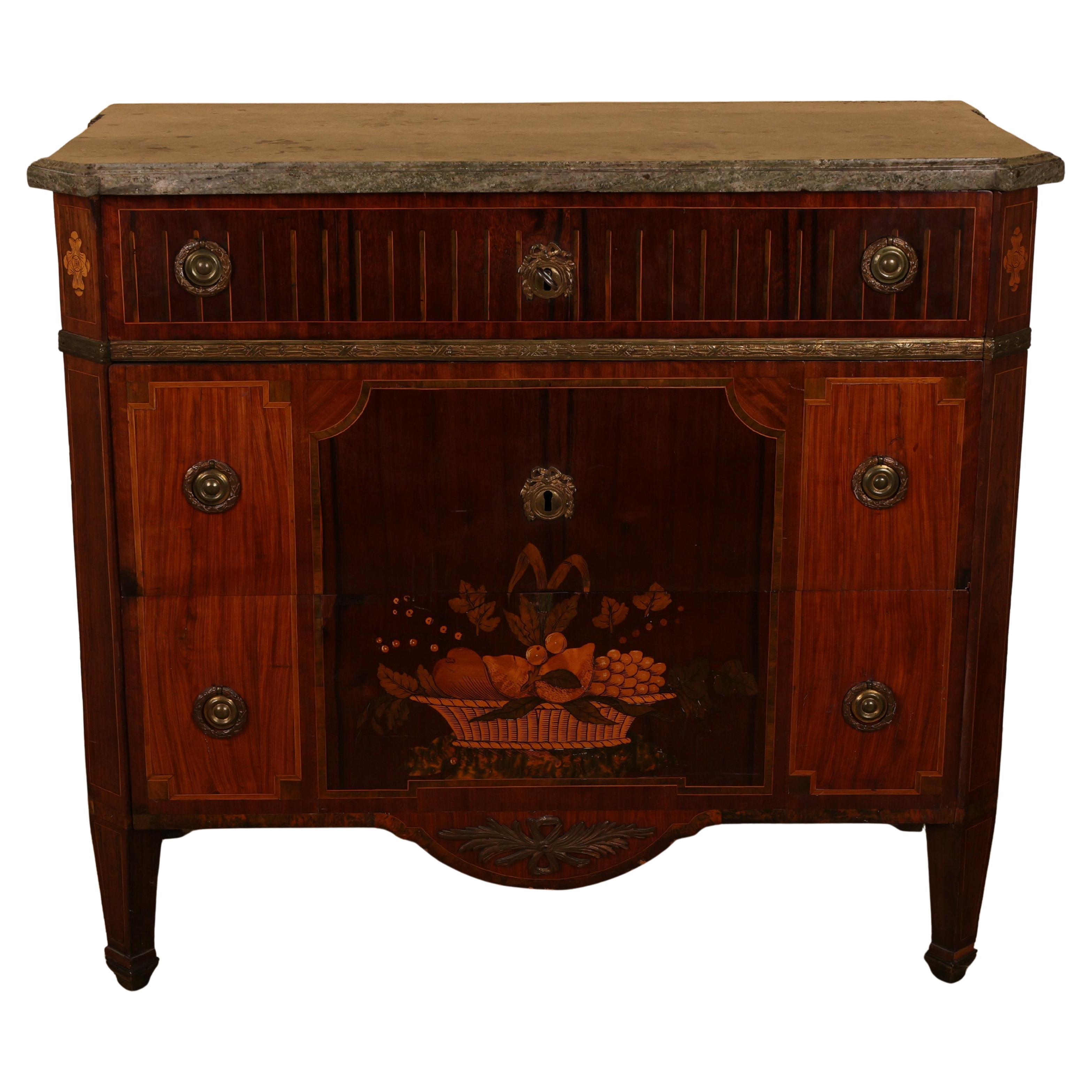 A distinguished high-Gustavian commode, crafted in Stockholm by Gustaf Foltjern (master 1771-1804). The top features an original slab of Kolsmo marble, while the body is veneered in various woods on a frame of pine and alder. The front is adorned