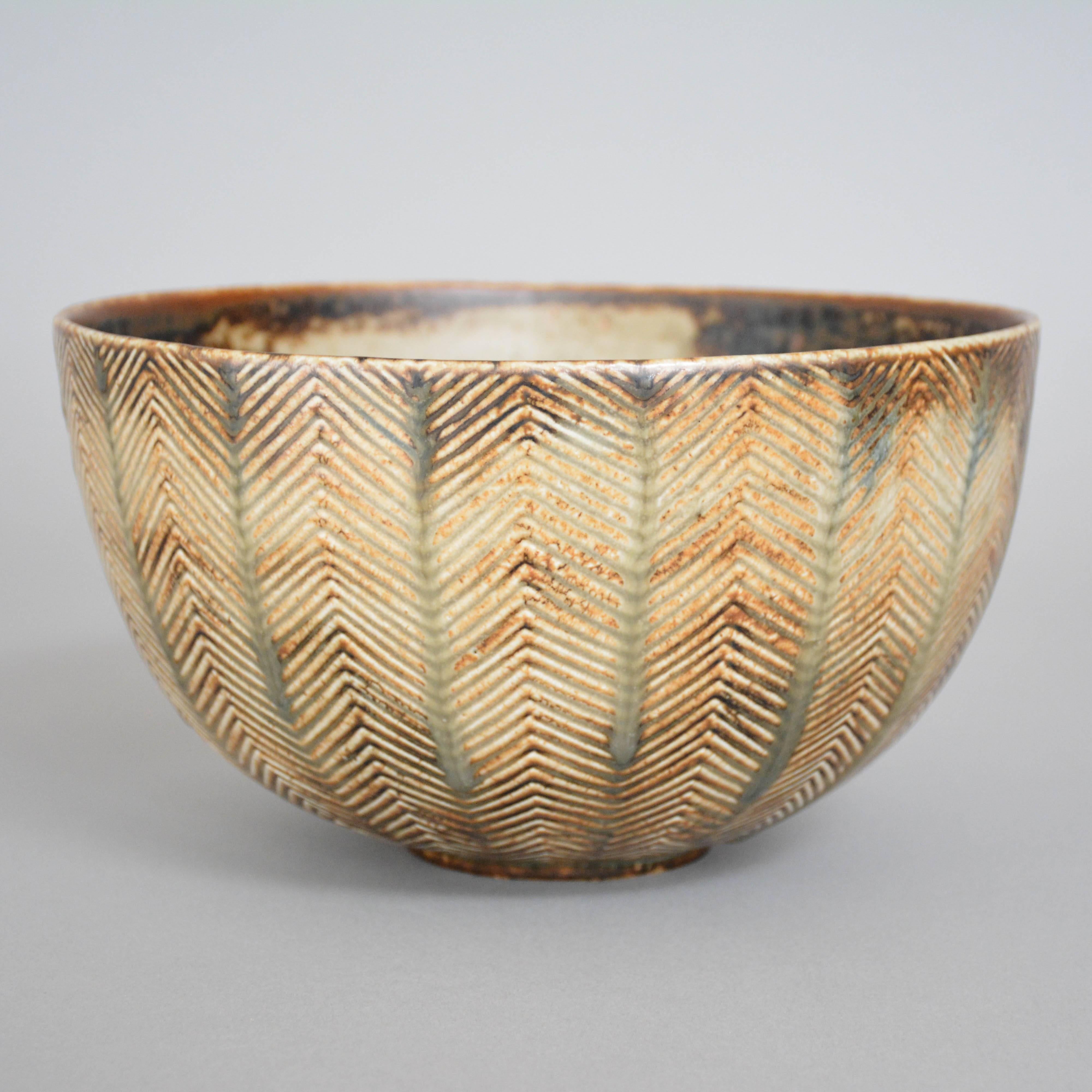 A stoneware bowl by Axel Salto for Royal Copenhagen, Denmark. Carved line pattern to exterior. Sung glaze.