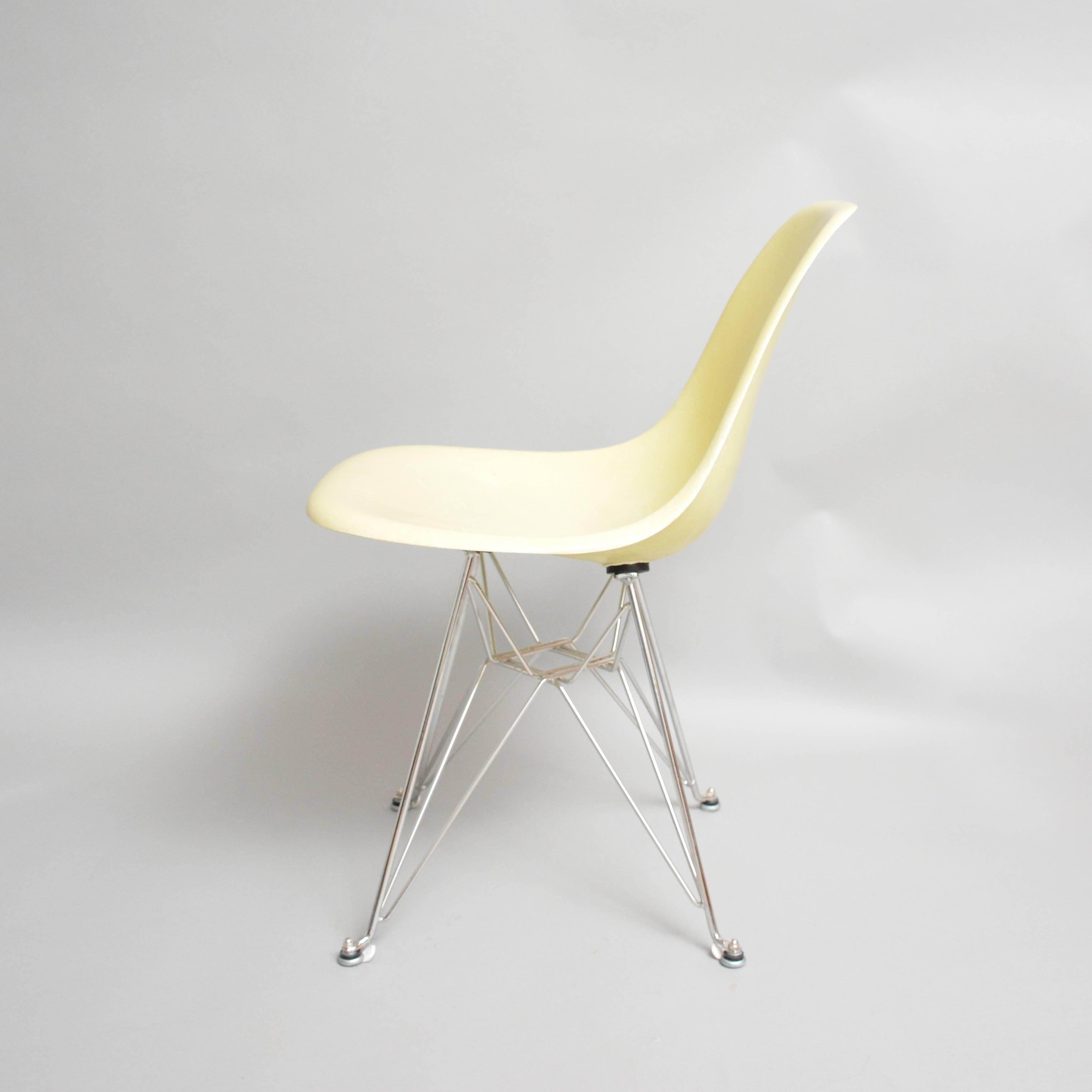 Eames side shell chair in lemon yellow and on eiffeltower reproduction base. The shells are produced by Herman Miller, US. Four chairs available.