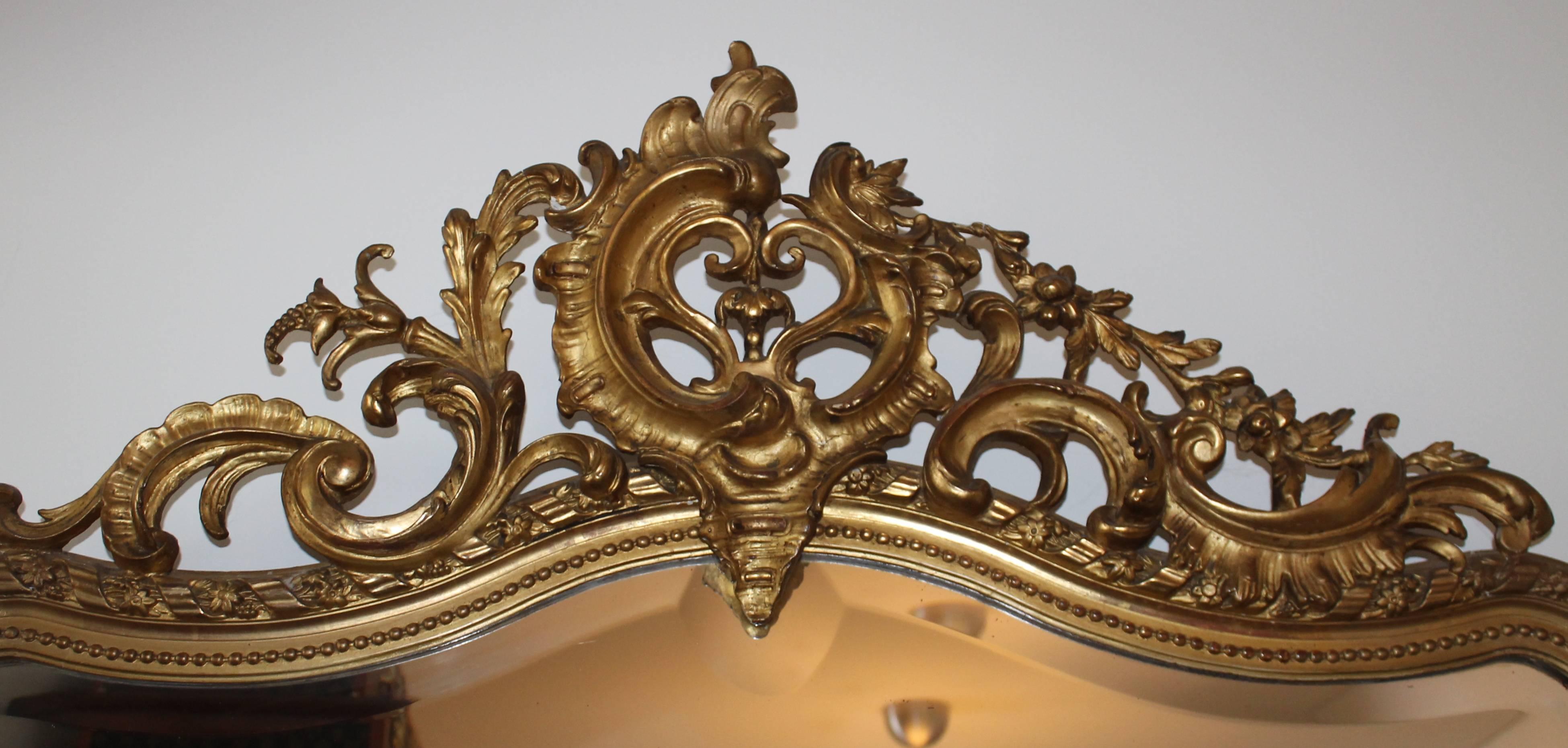 Tall mirror for hall or fireplace in gold with beautiful details.