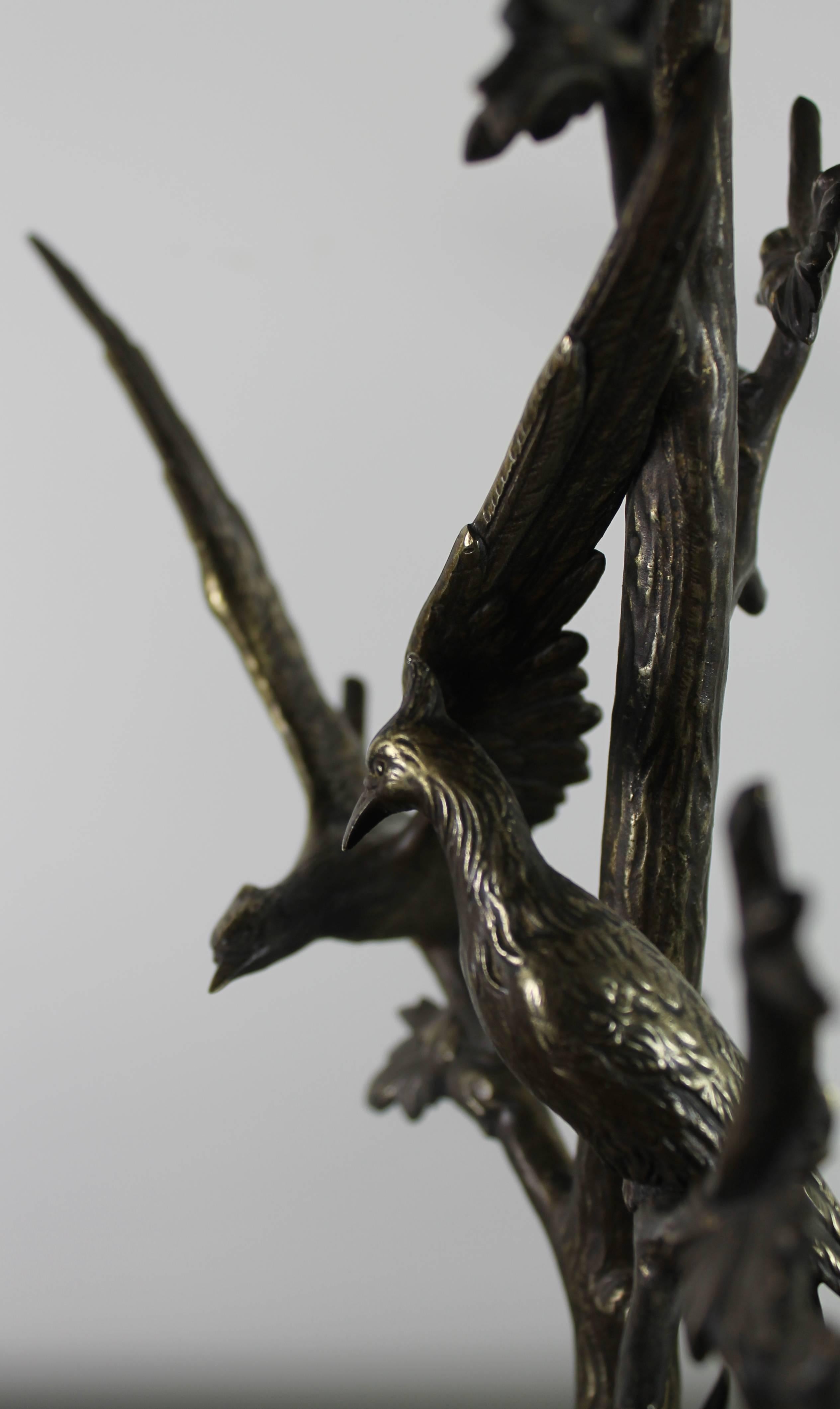 Table lamp in bronze with two birds in a tree, on a marble base.